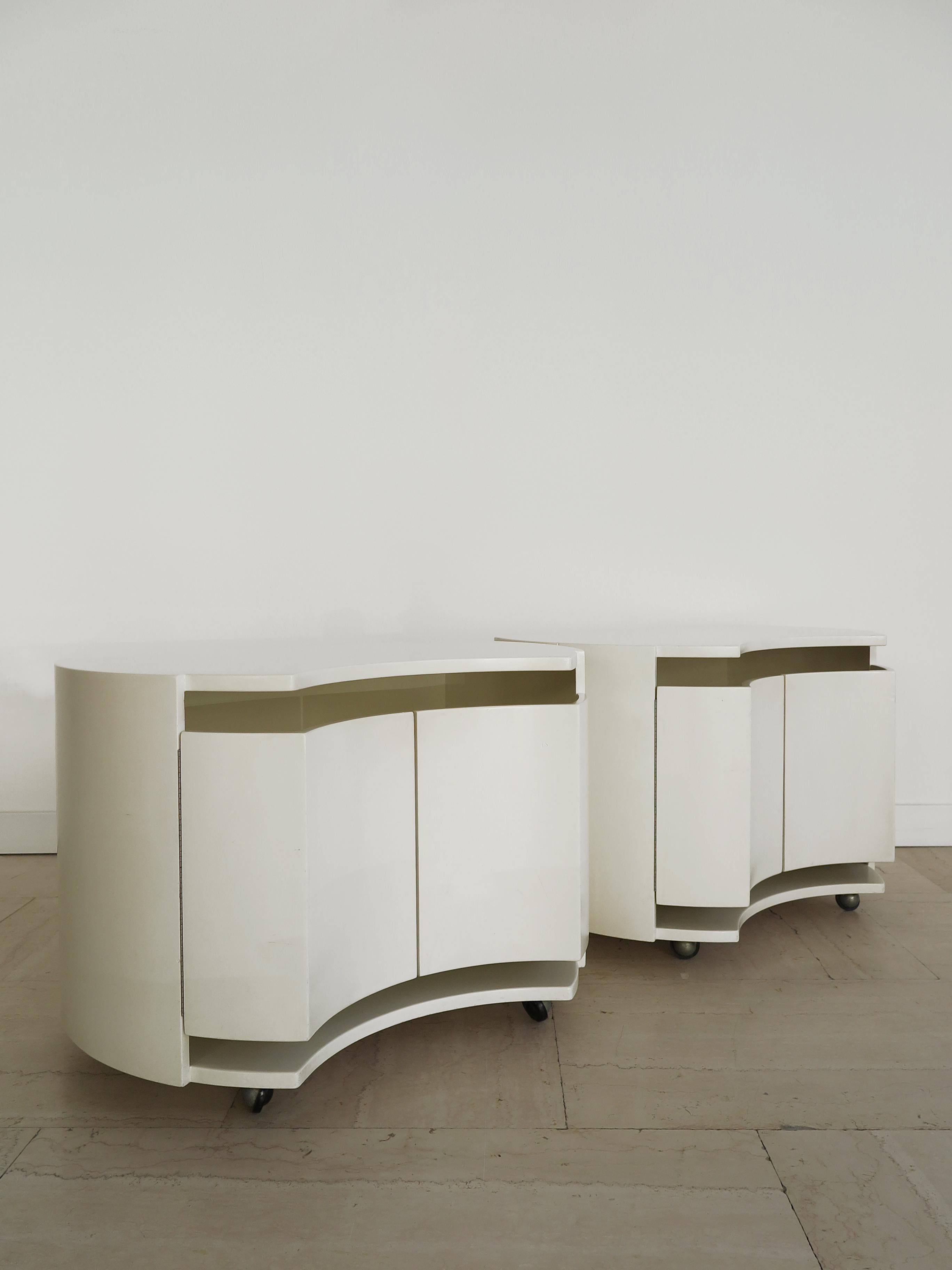 Italian ivory white lacquered wood frame nightstands bedside tables designed by Katzuide Takahama (attributed) and produced by Simon Gavina with opening doors and interior shelf, wheels chrome metal wheels under base, Italy 1970s.

Please note that