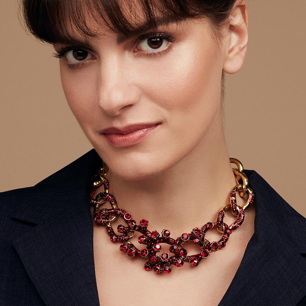 An opulent necklace that swathes the neckline in crystal coral forms. A highly crafted piece, each link evolves with added detail and texture towards its sculptural centre piece. The links of the necklace graduate from smooth at the back to become