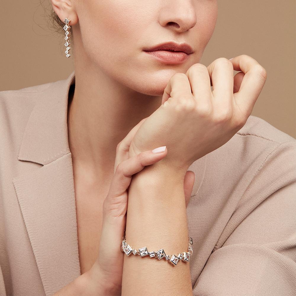 The Icicle bracelet is formed from a sequence of square cut cubic zirconia stones seamlessly interlinked at off-set angles following the natural flow of crystal formations. The fastener is a cleverly constructed rocker-clasp, concealed and secure,