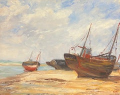 Des bateaux de pêche en bord de plage se reposant sur la côte, sous un ciel nuageux
