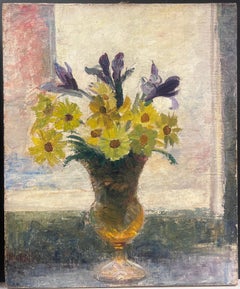 Nature morte lumineuse avec marguerites jaunes et iris violets dans un vase en verre