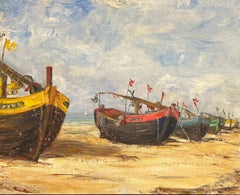 Des bateaux de pêche colorés sur une plage de sable sous un ciel nuageux, France, années 1930