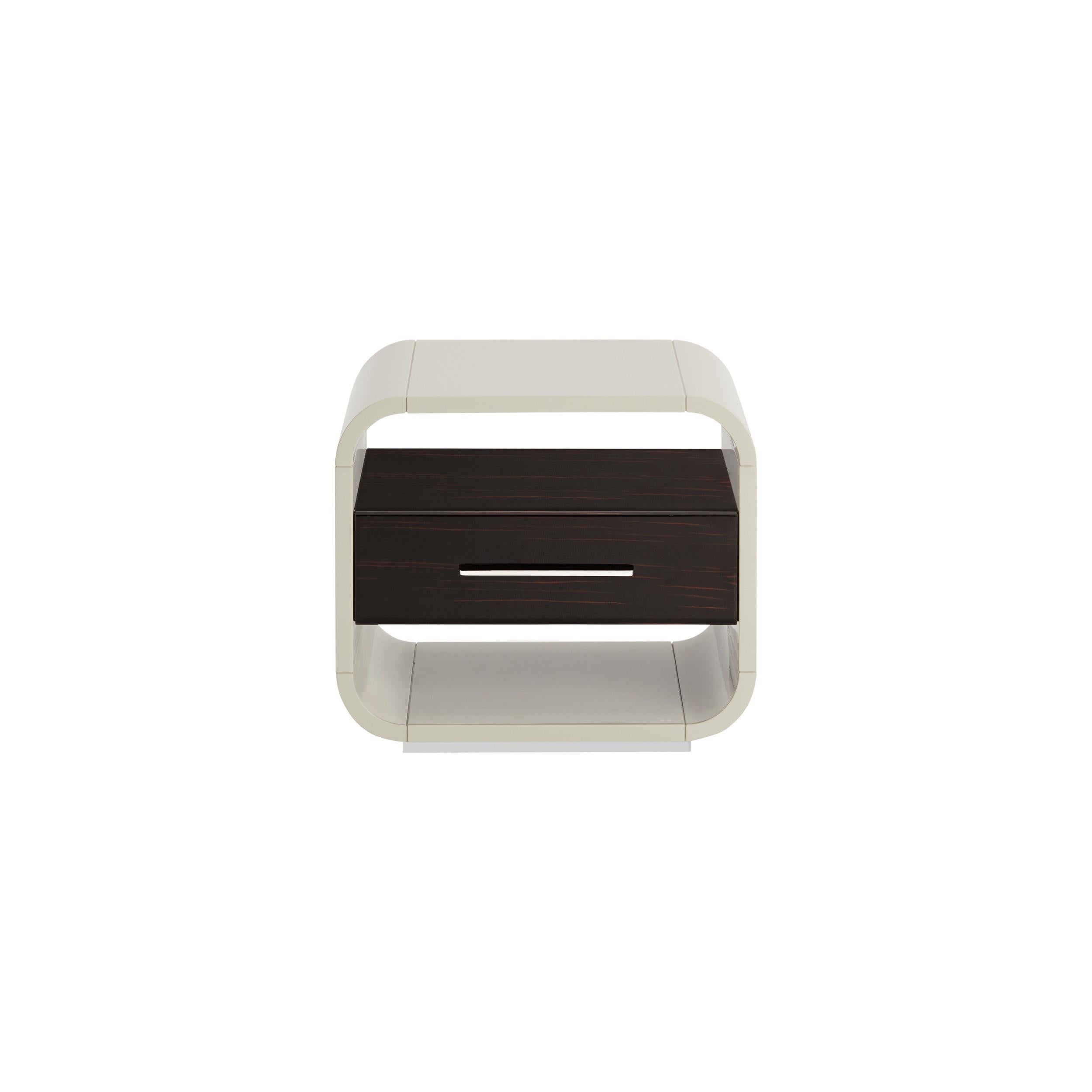 The shaped structure gives the bedside table SIMONE a contemporary style, made with a lacquered wooden structure with an integrated drawer in veneered wood.‎ Simone is characterized by customizable details and matching or contrasting finishes on the