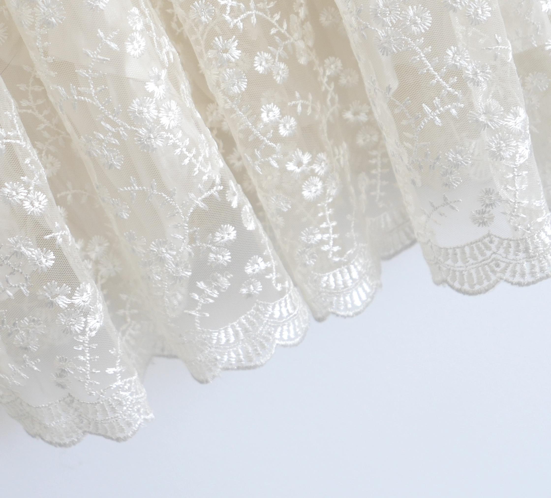 Robe féminine et excentrique Simone Rochas à jupe bulle brodée. Porté une fois. Réalisée en voile de polyester crème et ornée d'une délicate broderie florale en couleur, elle présente un corsage ajusté et une jupe bouillonnante à panneaux avec