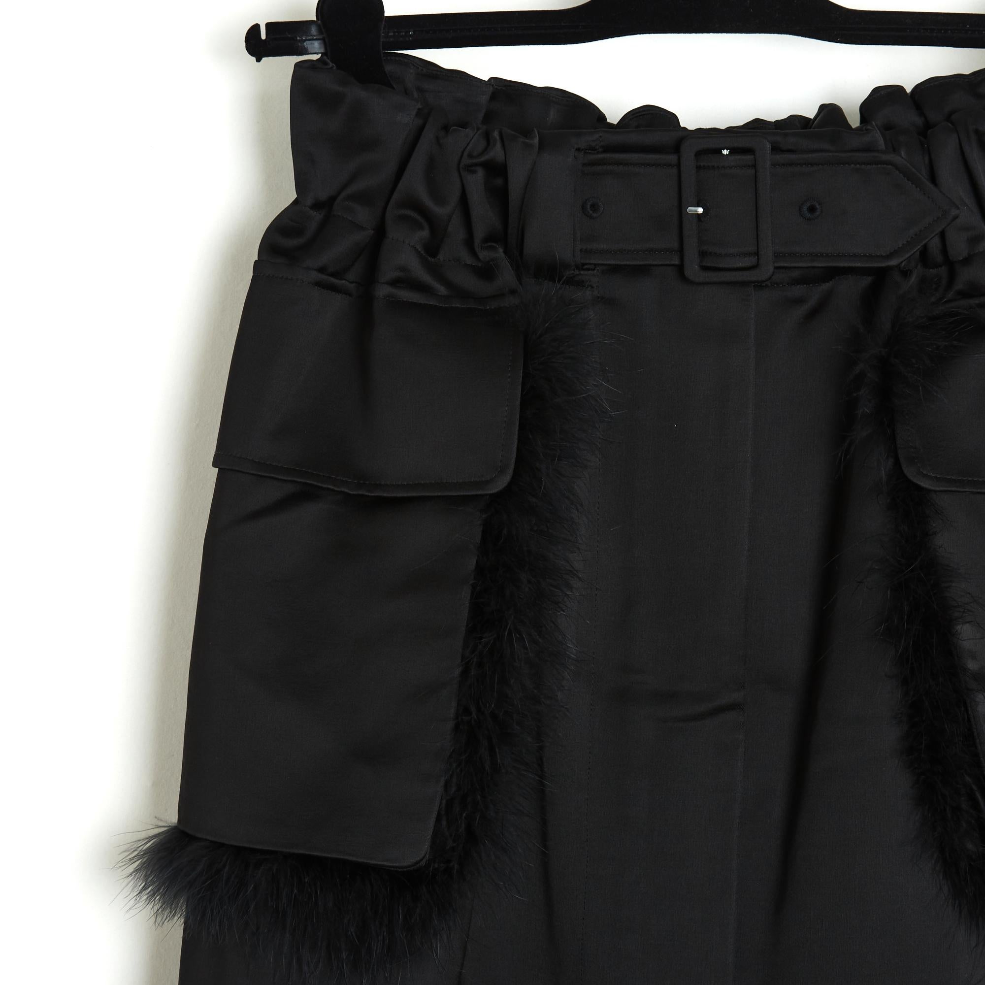 Simone Rocha skirt with military or safari inspiration in thick black cotton and viscose satin, slightly corolla shape pleated on the sides and back by the wide elastic waistband, front closure with a long double-slider zip over the entire height of
