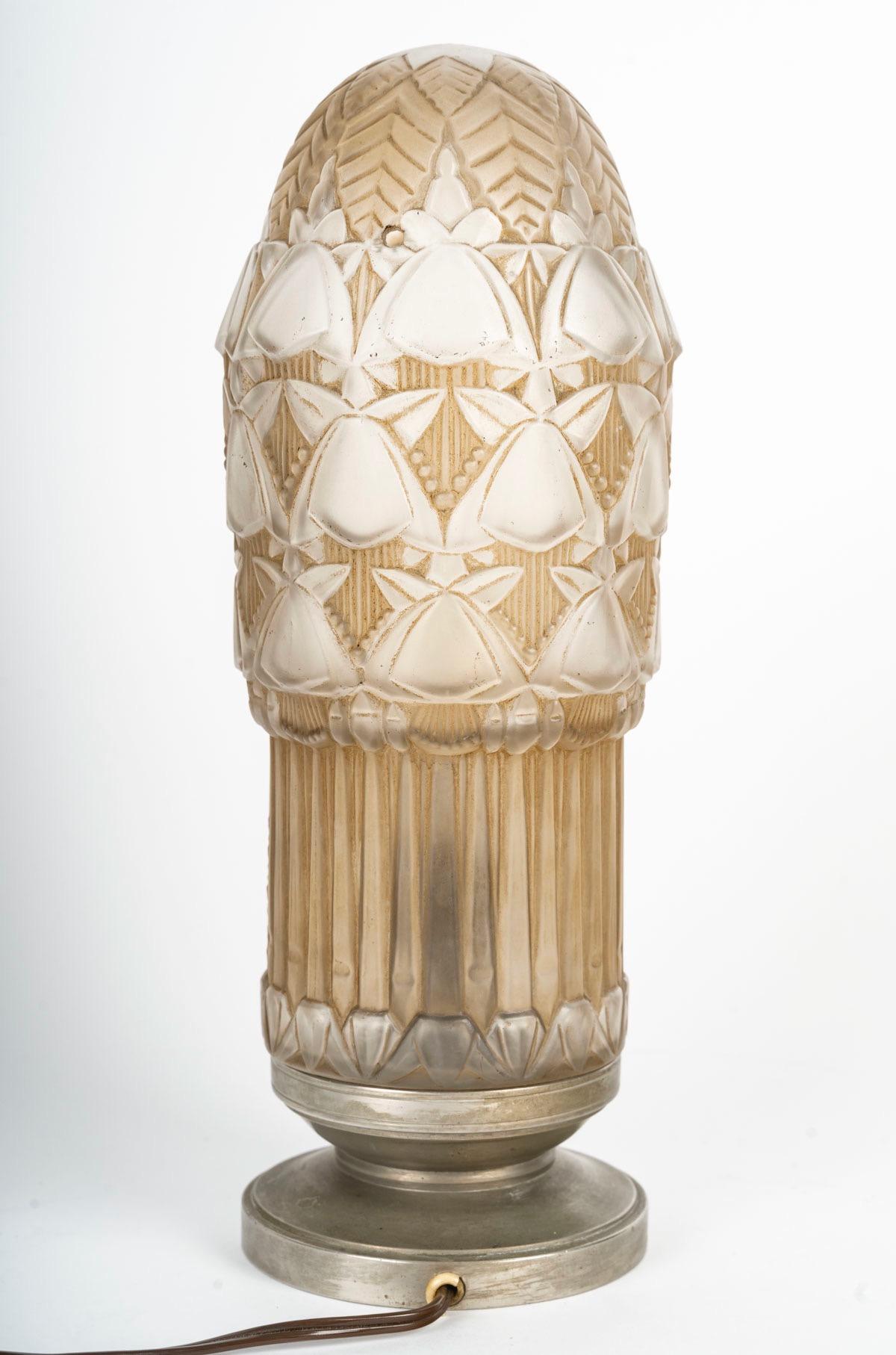 Simonet Frères Éditeurs y Henri Dieupart, Lámpara eléctrica Veilleuse, hacia 1930
Rarísima lámpara Veilleuse de cristal moldeado prensado, satinado y patinado              
Tapa de bombilla de cristal atornillada a una base de acero niquelado que