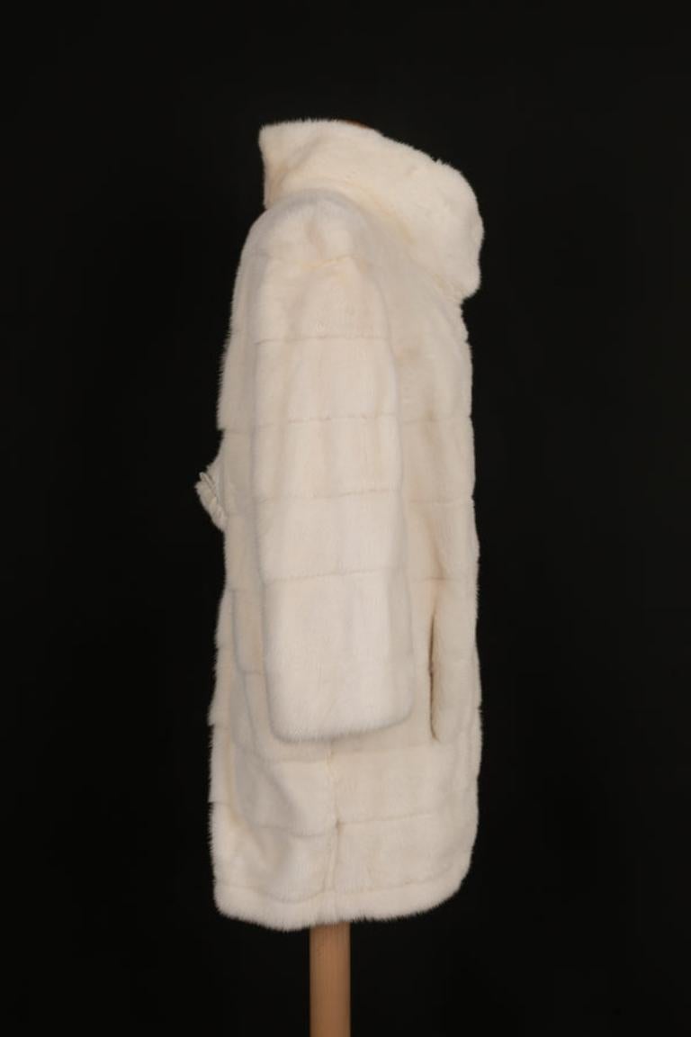 Simonetta Ravizza - Manteau en vison blanc avec un travail horizontal et une patte de serrage dans le dos. Taille 42.

Informations complémentaires :
Condit : Très bon état.
Dimensions : Largeur des épaules : 41 cm - Largeur de la poitrine : 49 cm -