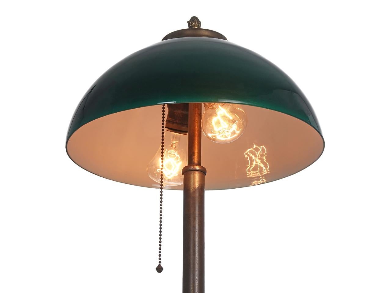 This is a very simple and elegant desk lamp that will fit comfortably alongside any decor. It has just the right look. The rare 12 inch dome is green over white sandwich glass. We have not refinished the brass and left the original aged patina.