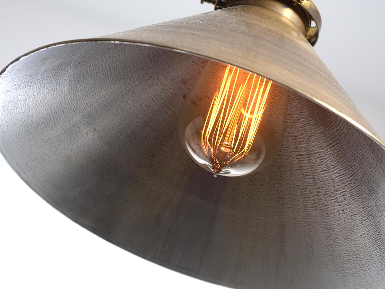 This is a nice simple spun brass shade It is heavy gauge with a rolled edge. The outside hde a dark brass finish and the inside is lightly silvered. There s 10 inch diameter and the hight is 7 inches plus the pipe drop length you require.