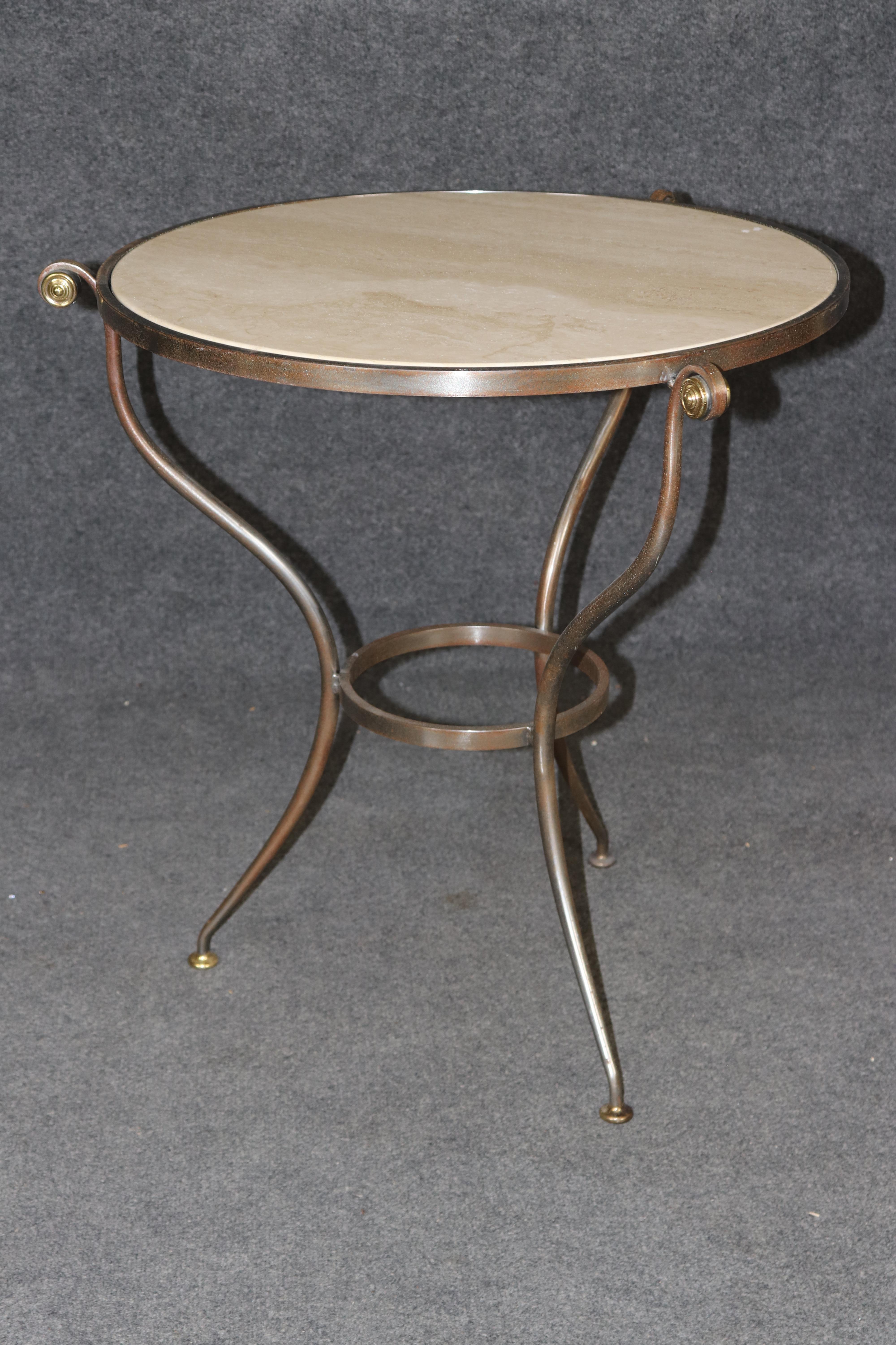 This is a superb, very well-made brass and steel gueridon or end table. The table is very chic and sophisticated and has delicately design details and is entirely hand-wrought metal. The travertine marble top is in good condition and the frame will