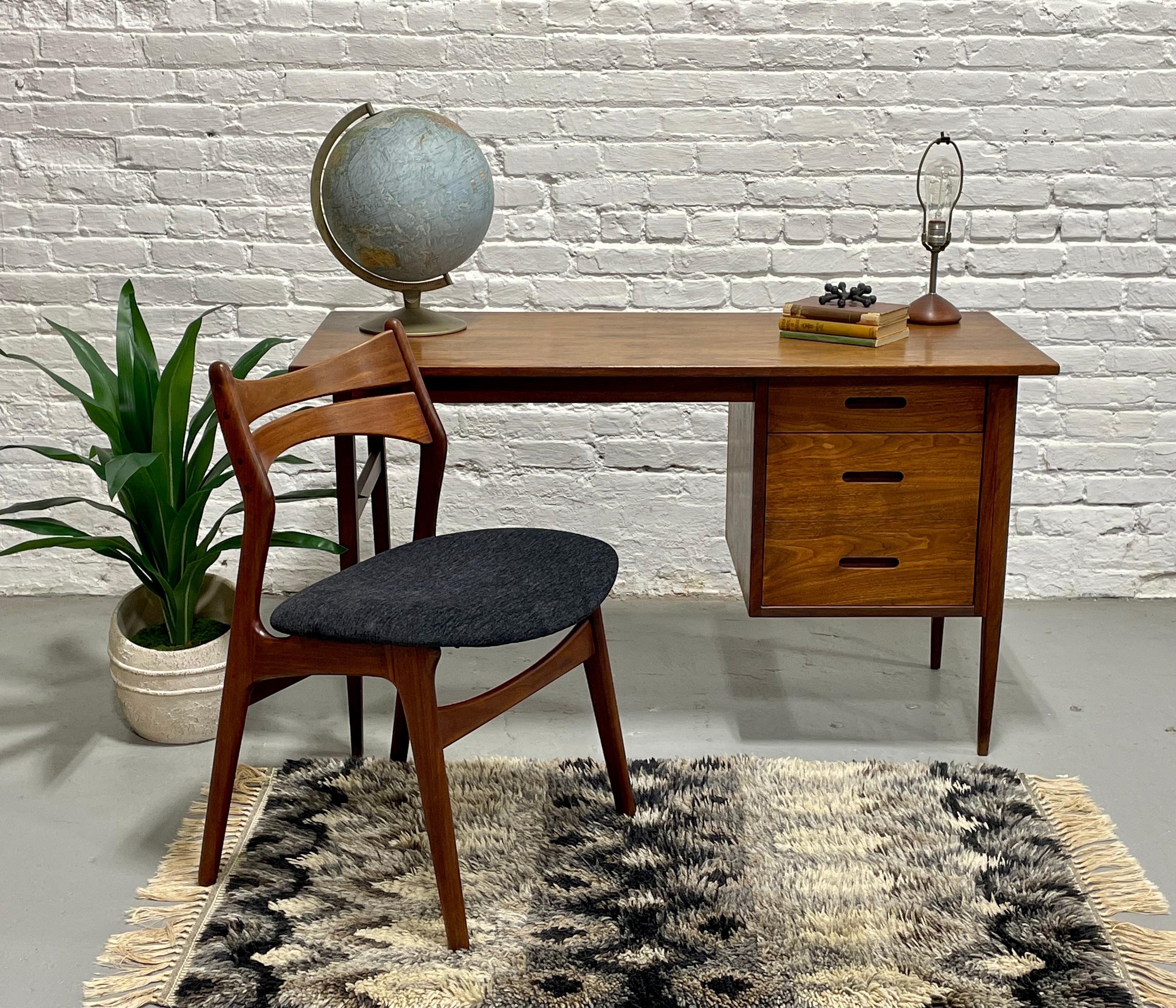 Clean + Simple Mid Century Modern Walnut Desk in the style of Arne Vodder, c. 1960's. Perfectly sized for smaller spaces, this walnut desk features two drawers, one of which is deep enough to work as a file cabinet so you can keep all your paperwork