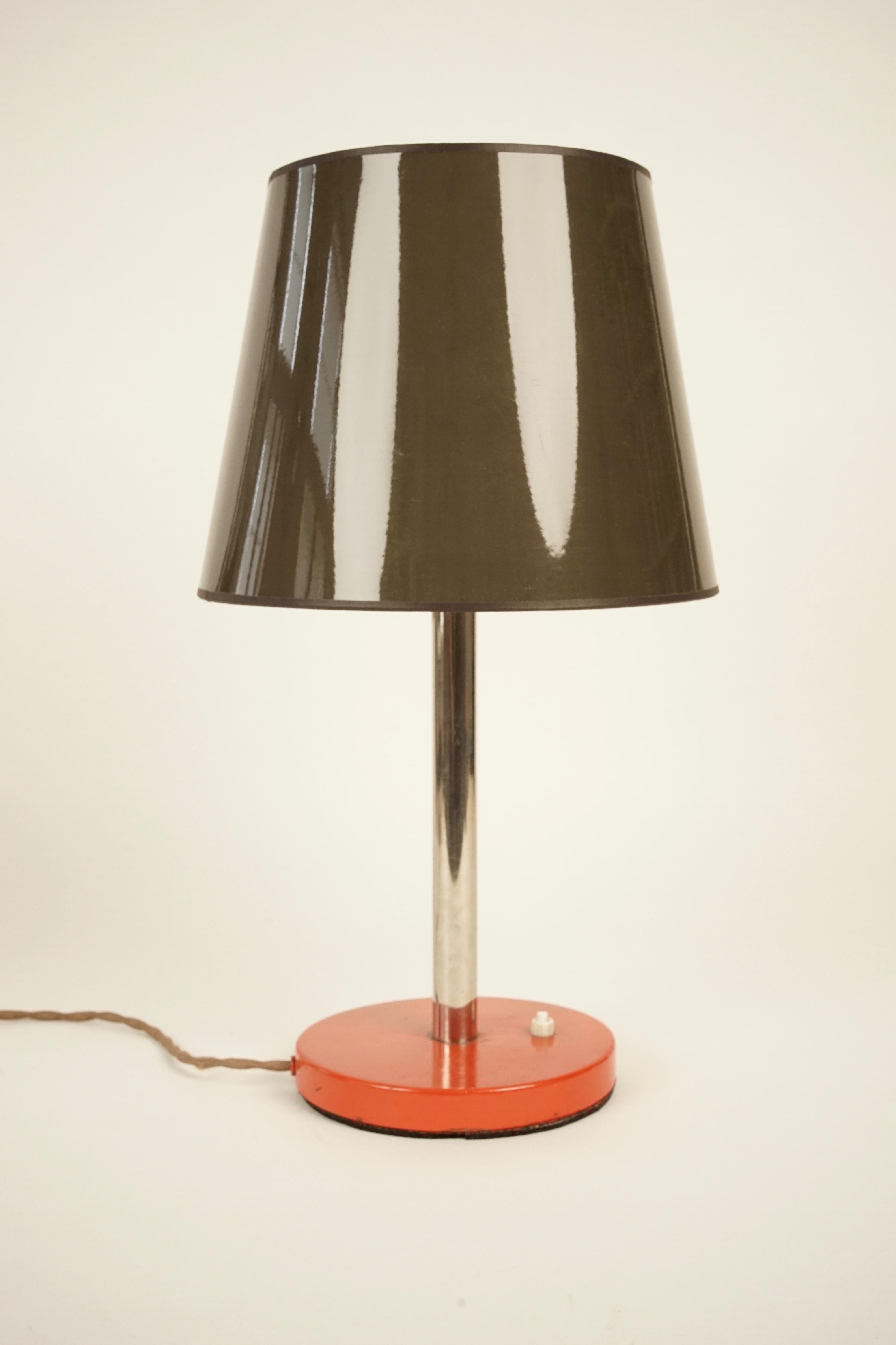 Une lampe de table simple et élégante des années 1930. Composée d'une base orange peinte et d'une extension chromée, la lampe supporte un nouvel abat-jour en gris et blanc. Le charme de cette lampe réside dans le contraste entre l'ancien et le