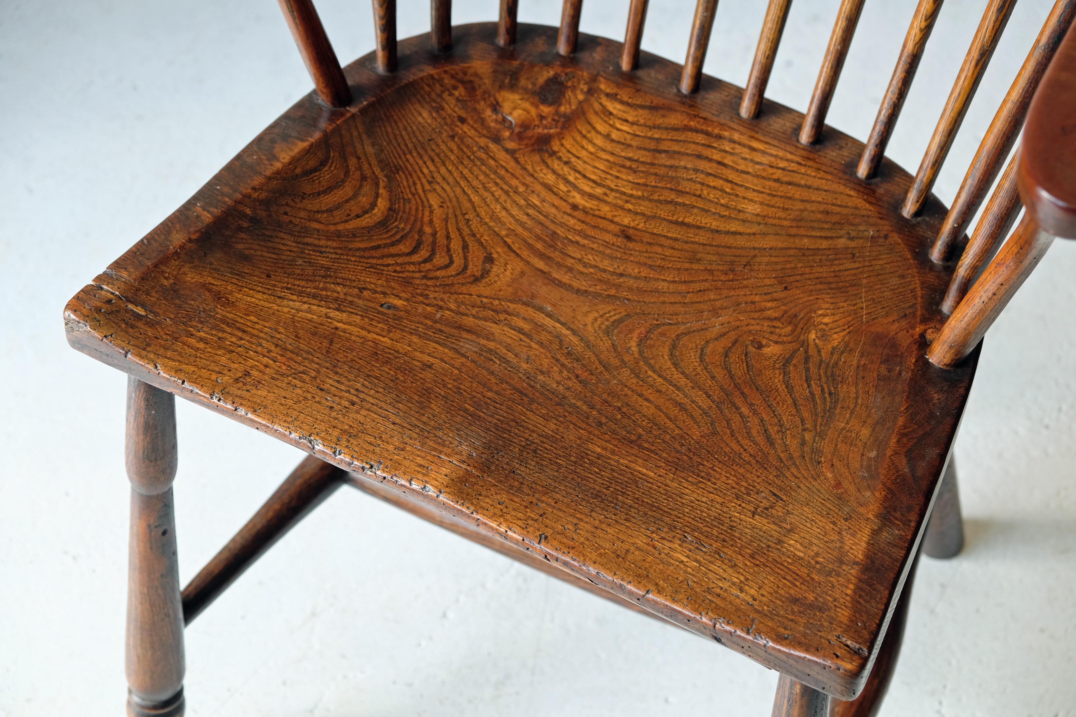 Simple and charming Windsor chair of West Country origin with shaped elm seat, beech and ash arms and hand-drawn spindles. Egg and reel turned front legs, simple plain tapered back legs, united by H stretcher. Lovely rich color with nice patination.