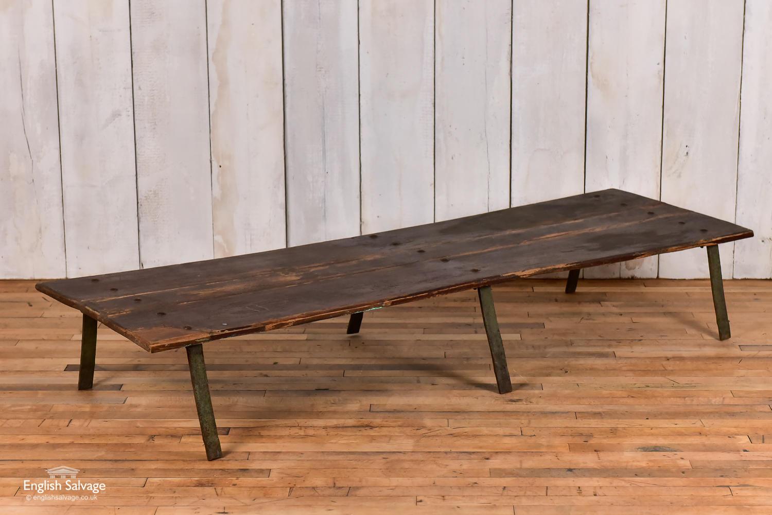 Simple hardwood coffee table with iron legs. Bolted top and angled leg design. Scuffs and scrapes to the top.