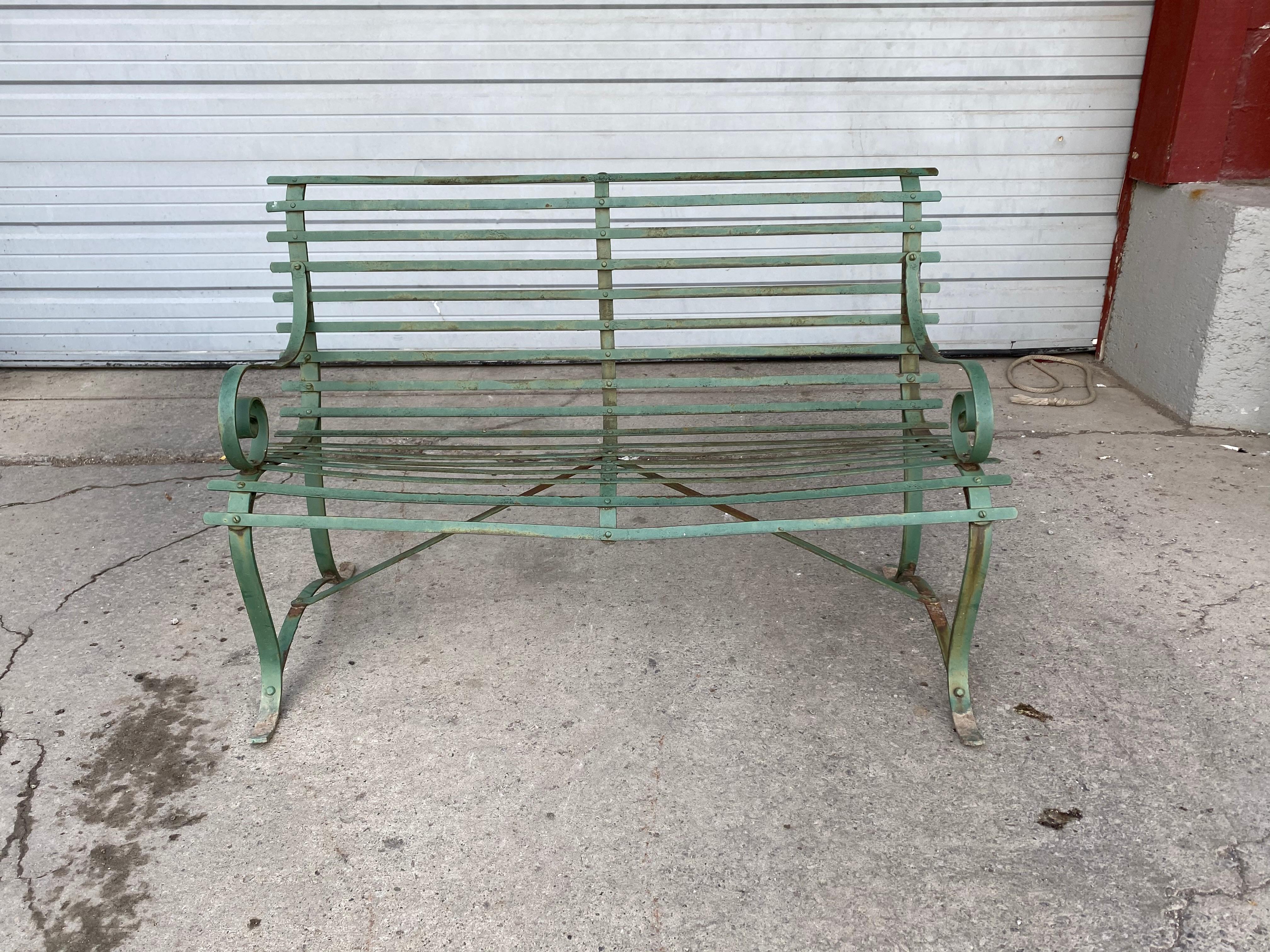 A simple, classic late 19th century, slat design wrought iron garden bench. Beautiful lines, Classic styling and design, wonderful patina, extremely comfortable.