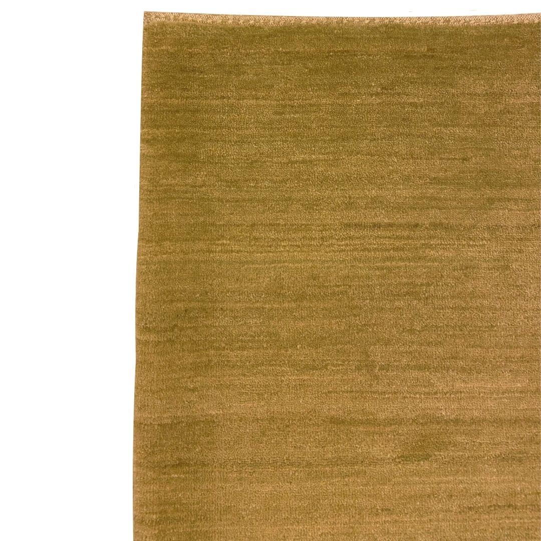 Dieser schlichte, moderne Perserteppich aus gedämpfter grüner Wolle mit den Maßen 2' x 3' verkörpert ein minimalistisches Design, das sowohl zu zeitgenössischen als auch zu traditionellen Interieurs passt. Sein dezenter, gedämpfter Grünton, der