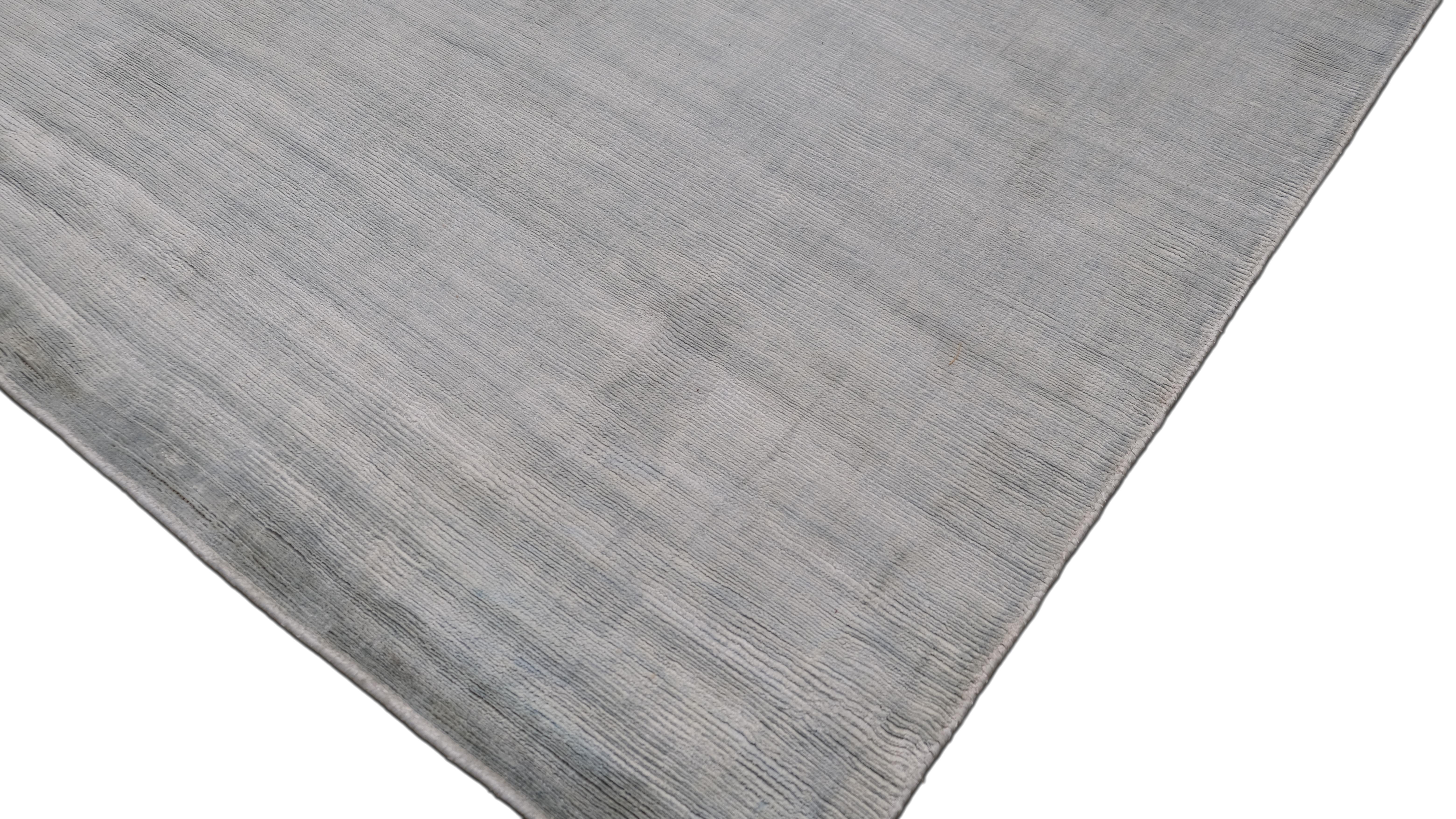 Enhance your space with the understated elegance of this hand-made bamboo silk rug. Featuring a luxurious soft blue tone with subtle variations, this piece offers a modern minimalist aesthetic that effortlessly complements contemporary, modern, and