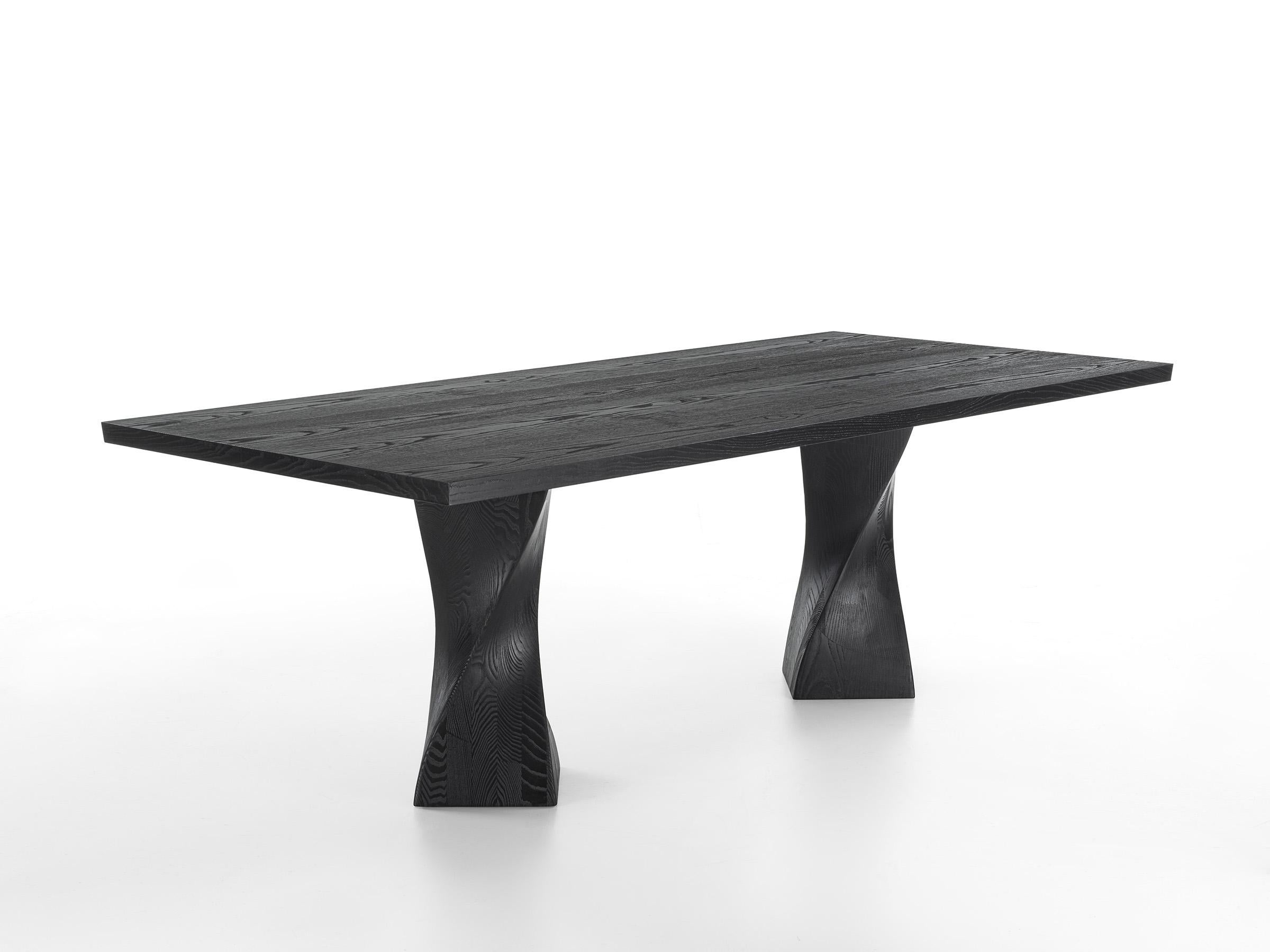 Table with blockboard veneered top and bevelled edges. It is characterized by two solid wood legs in pigmented finish. The processing gives it movement and dynamism. Legs in solid ash, pigmented.

Designed by Studio Excalibur and made in
