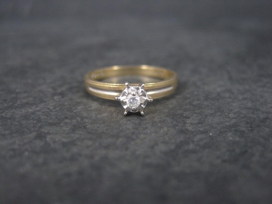 This gorgeous vintage engagement ring is 10K yellow gold with white gold accenting.
It features an illusion style head with a .06 carat natural round diamond.

It would make the perfect promise ring or engagement ring for that girl who doesn't want