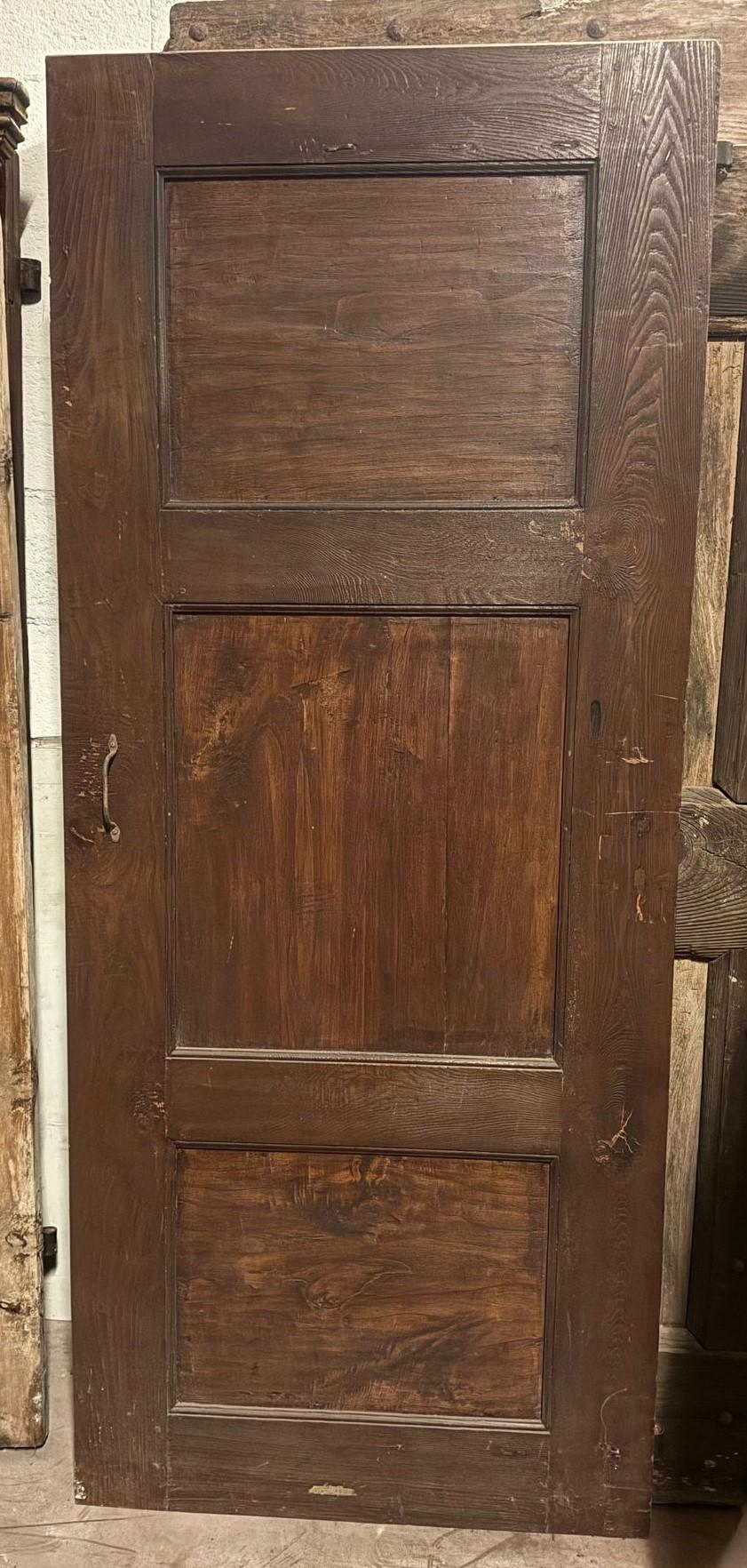 Ancienne porte simple en bois de chêne massif pour intérieur, avec un vantail sculpté à 3 panneaux, dos à panneaux, ouverture à poussée vers la droite, sans encadrement car installée directement sur le mur, donc avec fers d'origine. Période '800,