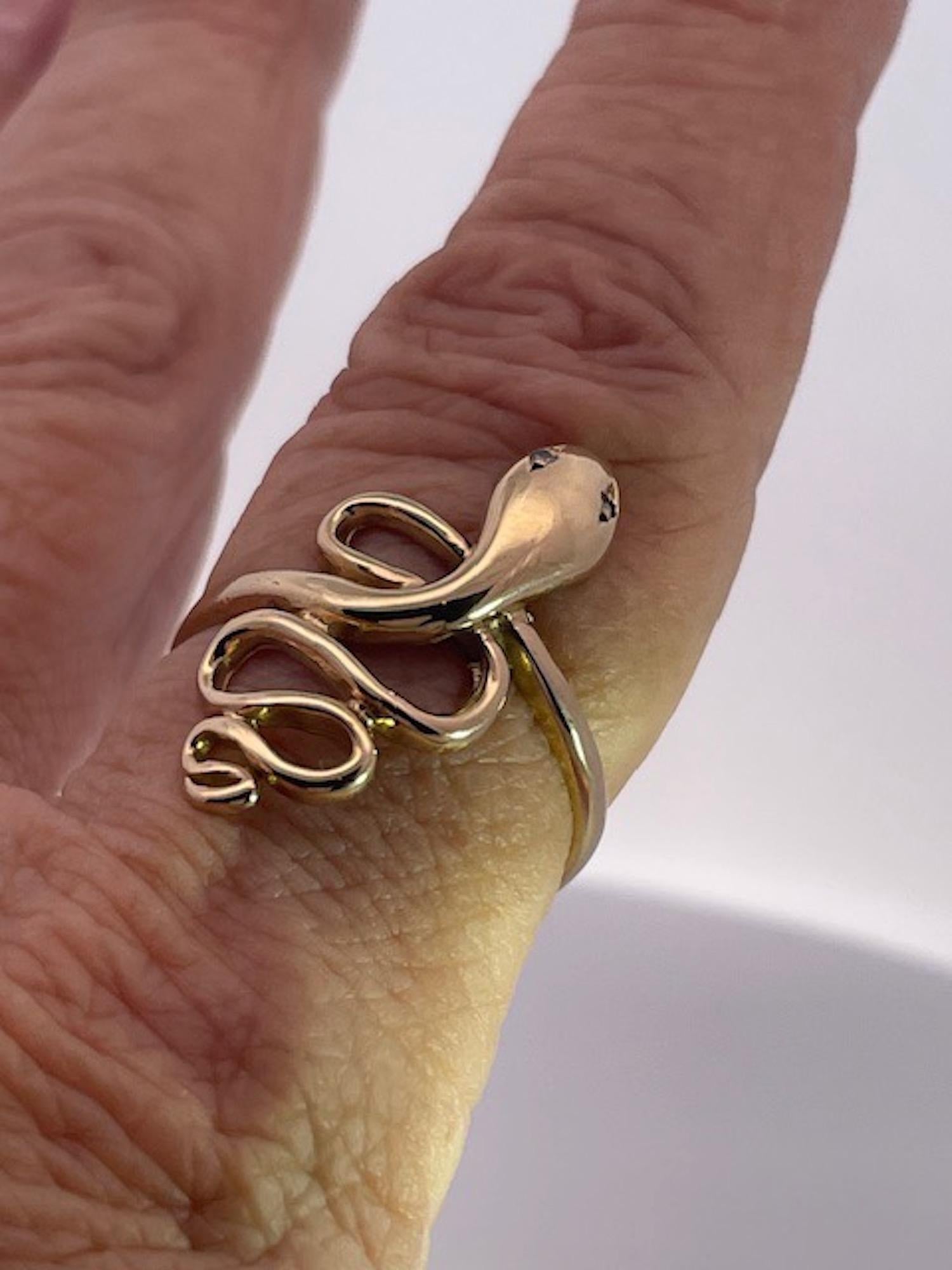 Este anillo procede de Alemania y es un sencillo anillo de serpiente de oro amarillo de 14 quilates.  Su talla es 9,75, pero puede aumentarse o reducirse.  Este anillo está limpio con una espiral enrollada cuatro veces y termina con la cola. 