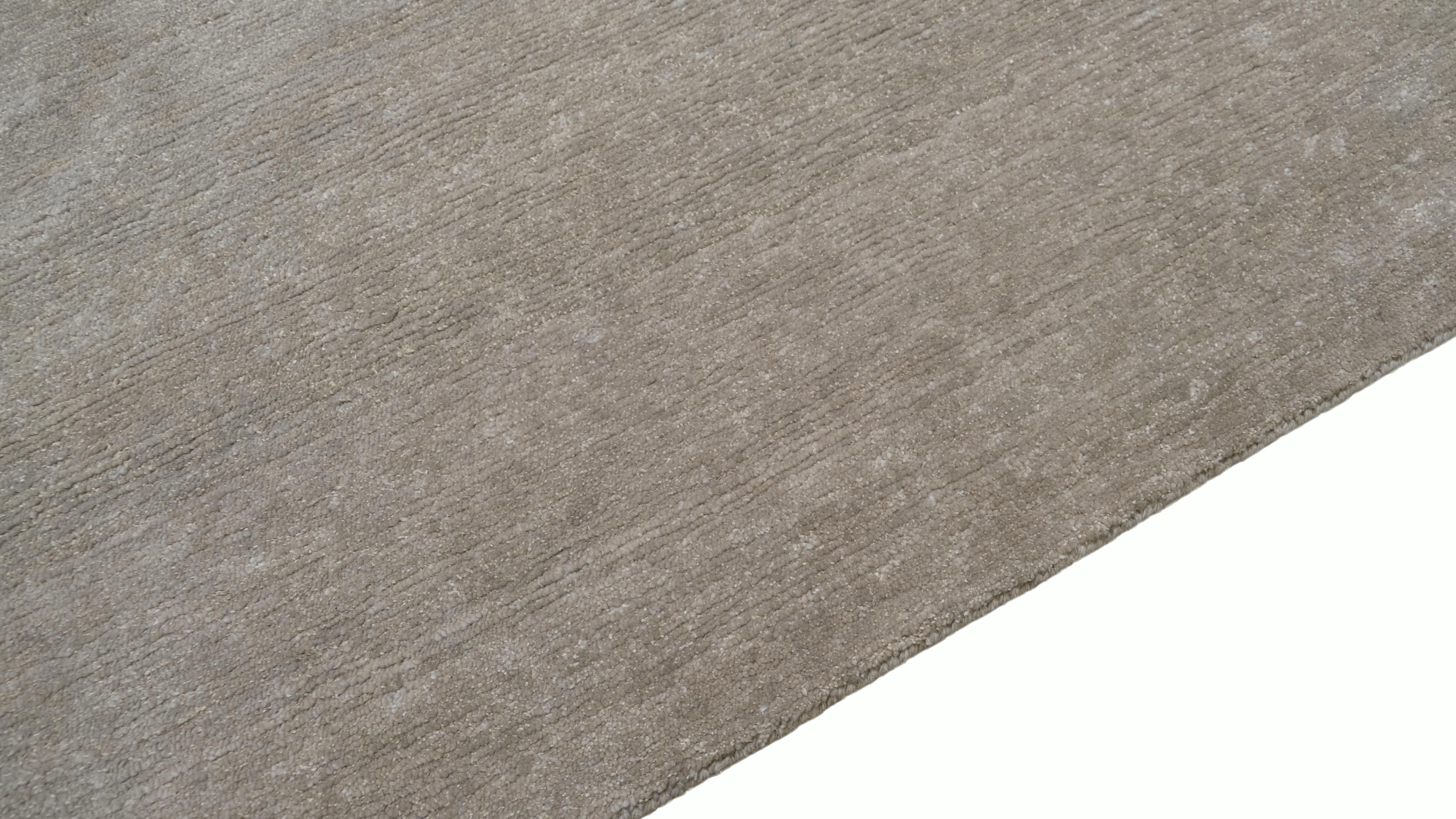 Élevez votre espace avec l'élégance discrète de ce tapis en laine noué à la main. Doté d'une palette de couleurs neutres sereines et chaudes et d'une texture lisse et sophistiquée avec une touche de lin, ce tapis apporte un sentiment de calme et de