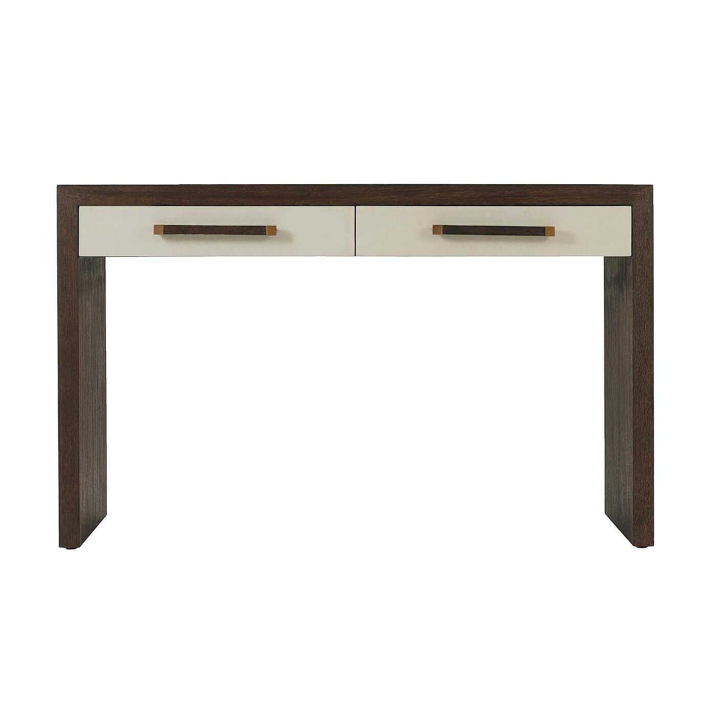 An elegant modern writing table with two singular leather-wrapped drawers, our Cardamon finish on the veneered frame (and handles) with panel end supports and brushed brass finish accents.

Dimensions: 49.25