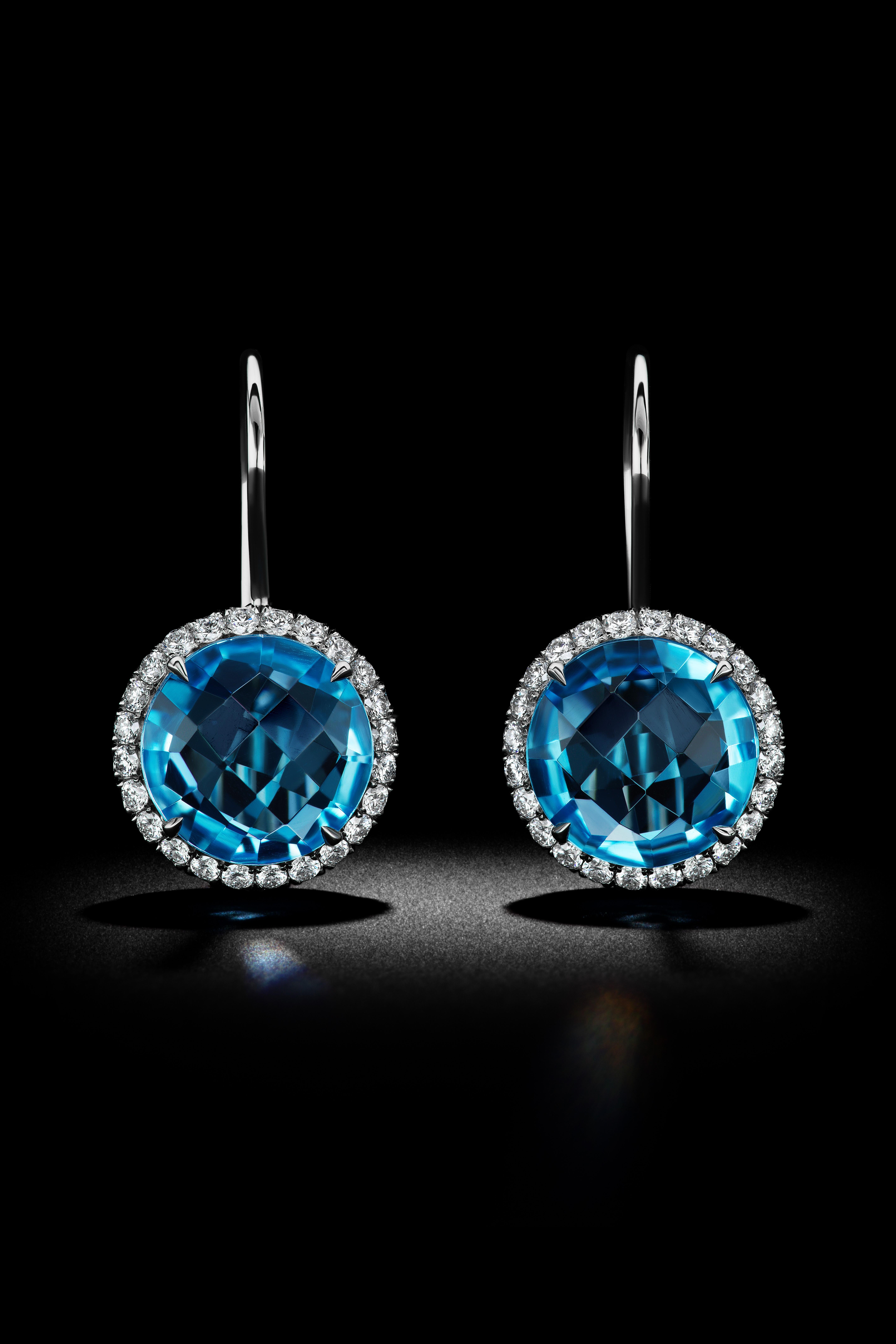 Simply stunning Blue Topaz Earrings surrounded by a Diamond Halo made in Platinum with 96 diamonds and 7.30 carats of Blue Topaz. 