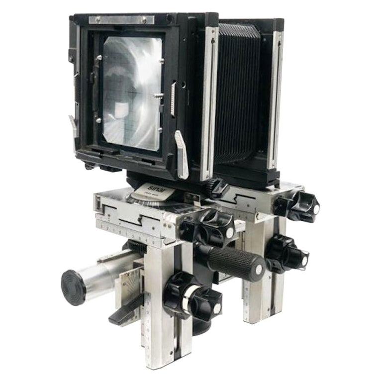 Sinar p 4x5 expert kit containing:
Sinar copal f5.6 auto aperture shutter & release cable
Sinar p 4x5 camera
Regular bellows
Wide angle bellows
4x5 ground film holder with fresnel mounted lens
4x5 polaroid back
Five 4x5 sheet film