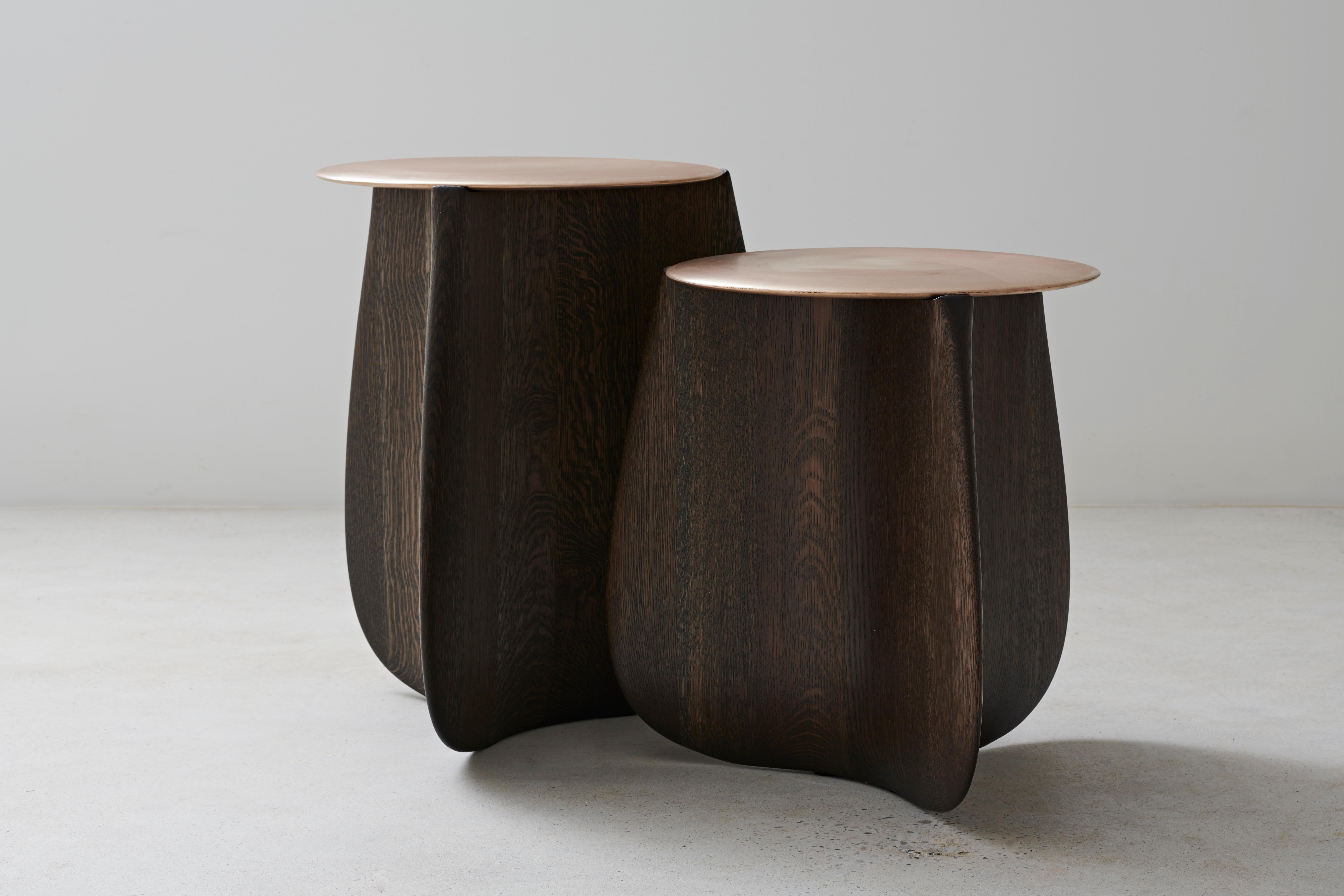 A burnished, cast bronze top perches on a sculpted, solid hardwood base on this organic side table by Izm Design. Available in 2 heights and a range of wood species and finishes.
 