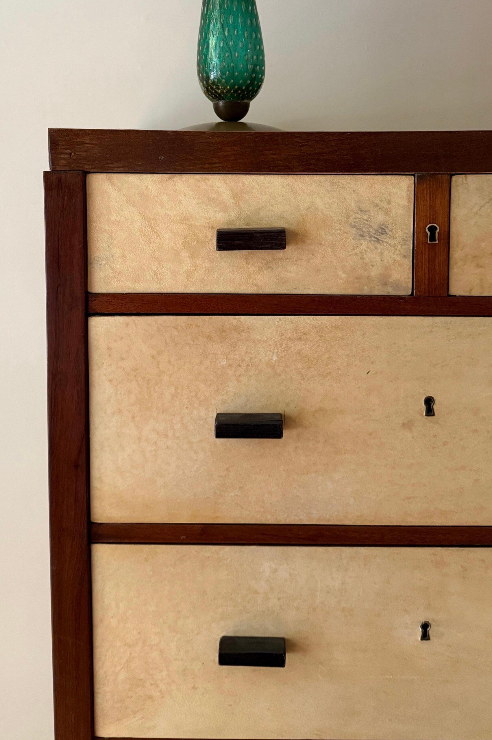 Cassettiera a 7 cassetti disegnata da Jacques Adnet, struttura in legno rivestita di pergamena. Francia, anni '60.