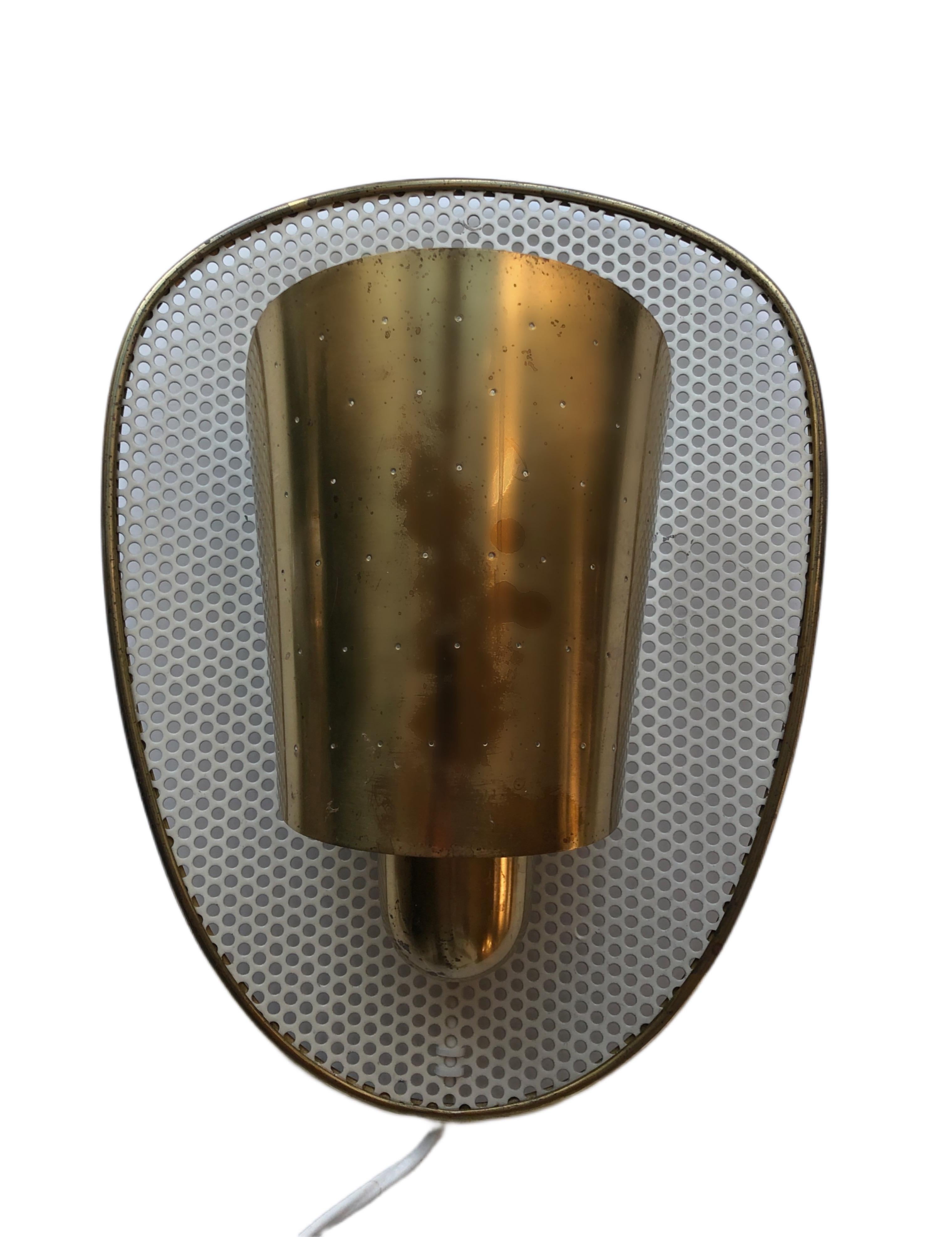 Single sconce attributed to Jacques Biny. Designed and manufactured in France, circa the 1950s. Perforated shade in brass. 

Jacques Biny is a major French luminary from the era of the glorious 30’s. Unlike other designers, he is also a publisher