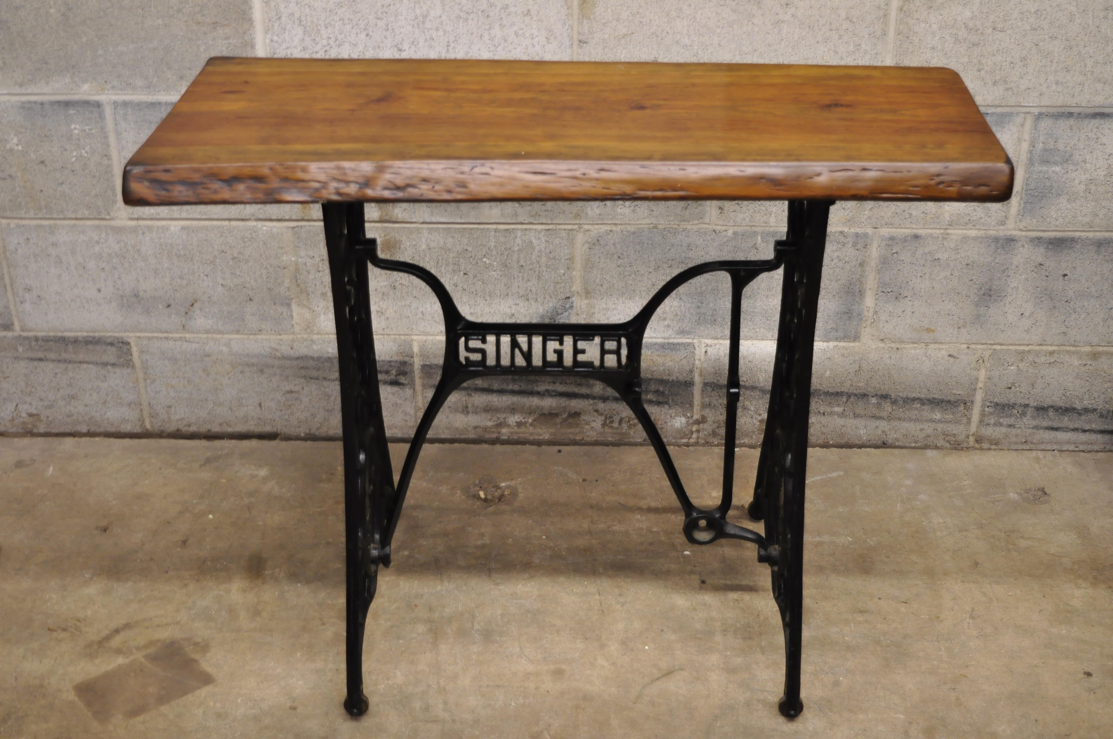 Antique singer cast iron Victorian sewing machine base console desk live edge slab top. Item features live edge wood slab top, cast iron singer base, beautiful wood grain, quality American craftsmanship, great style and form, circa early 1900s.