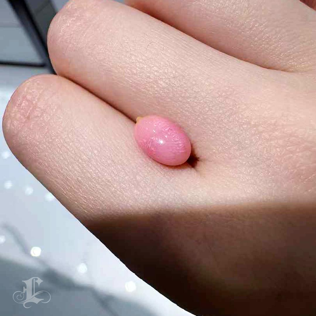 This breathtaking natural conch pearl showcases a rare and enchanting flamingo pink hue, complemented by a mesmerizing and well-defined flame pattern that dances across its surface. The pearl's organic form is further accentuated by a subtle calcium