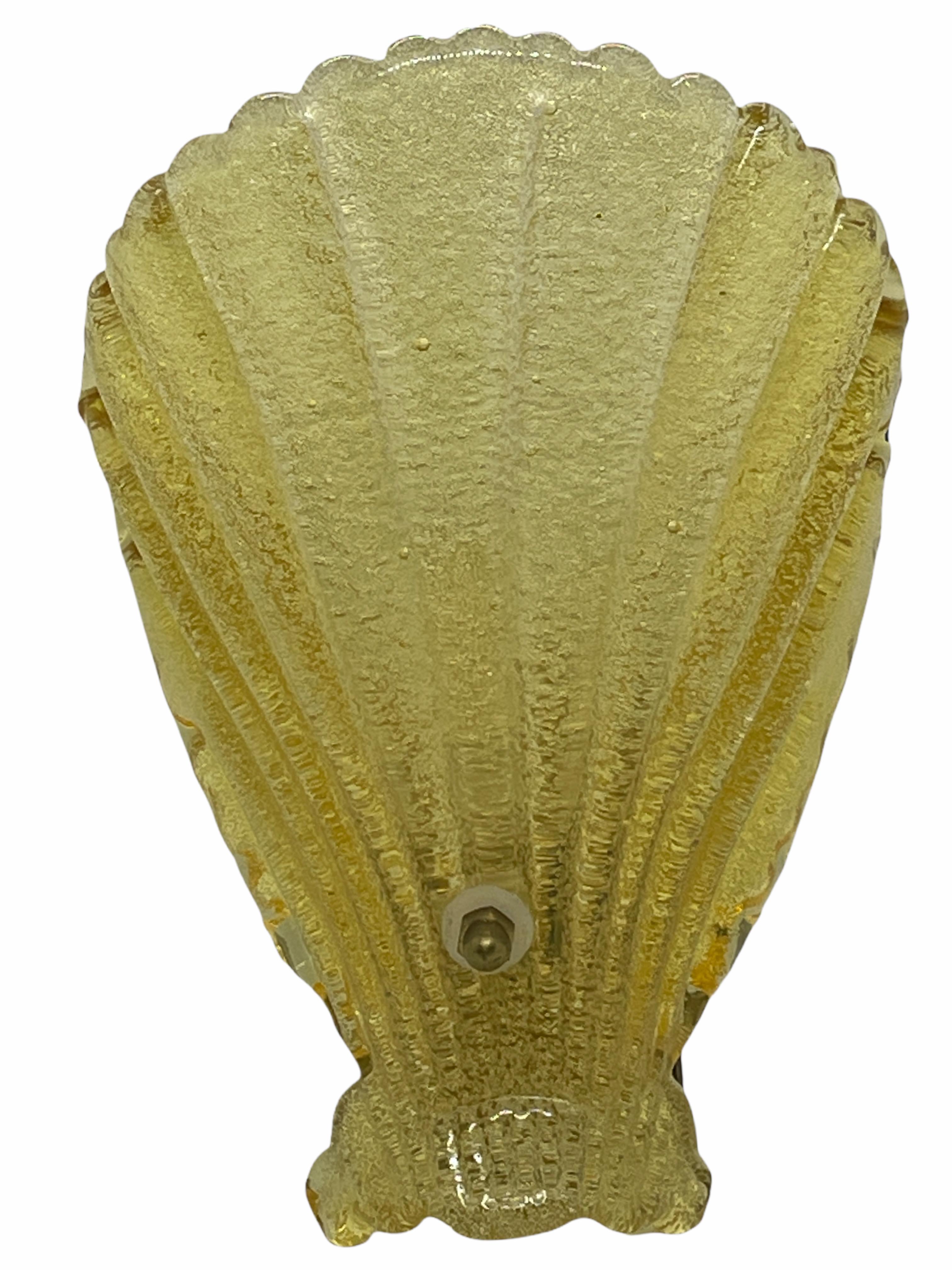 A single sea shell form wall light, produced in Germany by Soelken Leuchten, in textured glass, affixed against a brass base, circa 1960s. The glass shade is probably made in Murano Italy and base made in Germany. An iconic design from the 1960s and