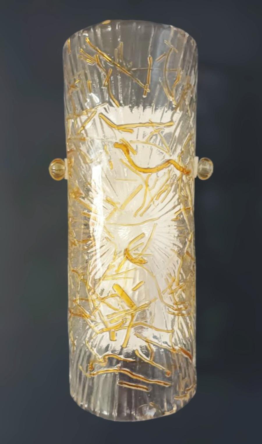 Italian wall light with a cylinder Murano glass shade in clear color with amber and gold texture, mounted on white metal frame / Made in Italy by Mazzega circa 1970s
Measures: Height 12 inches, width 6 inches, depth 3.5 inches
1 light / E12 or E14
