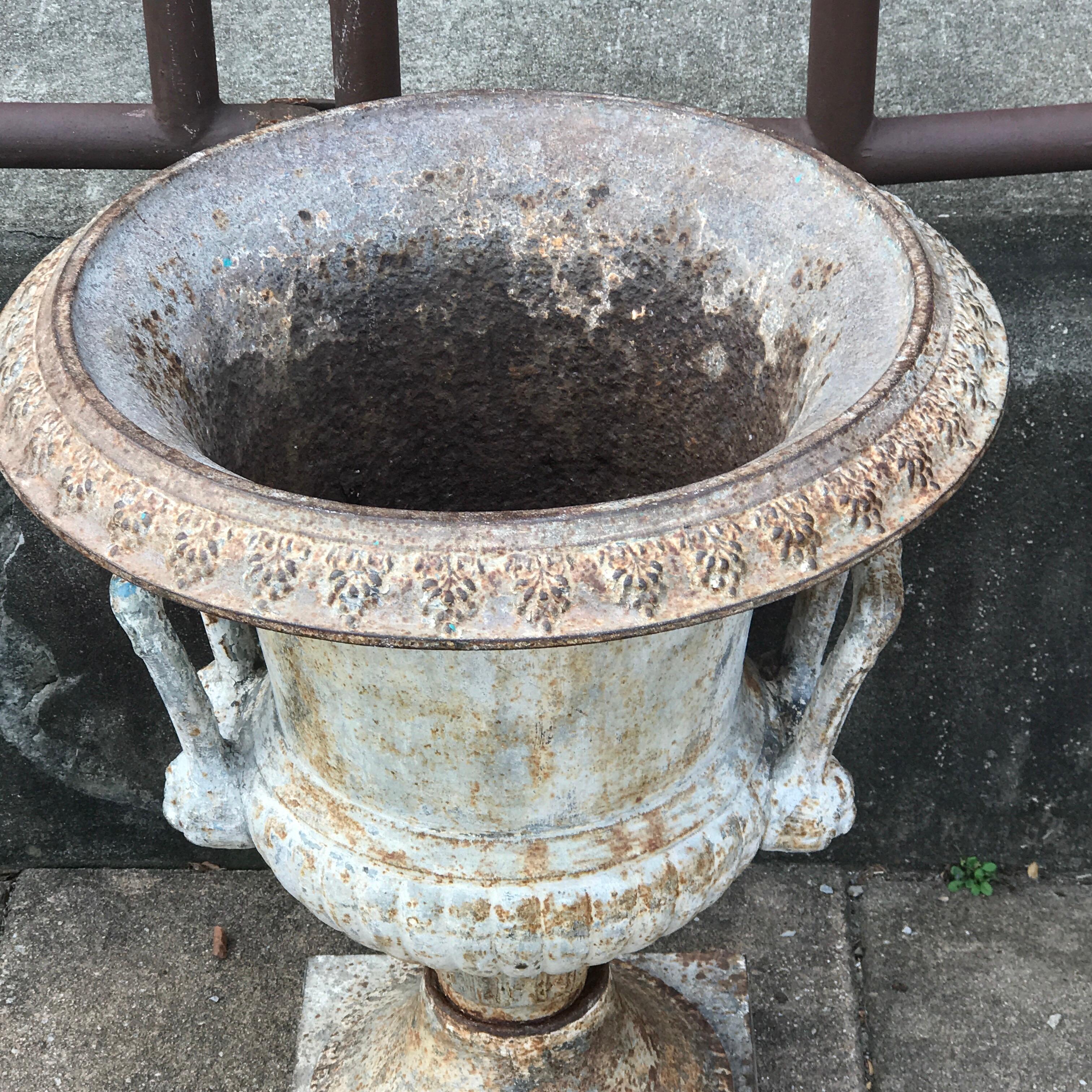 Single antique English cast iron garden urn, stamped Spicer & Peckham, 1887, in three parts, distressed verdigris patina, with acanthus handles. Interior measurements are 16