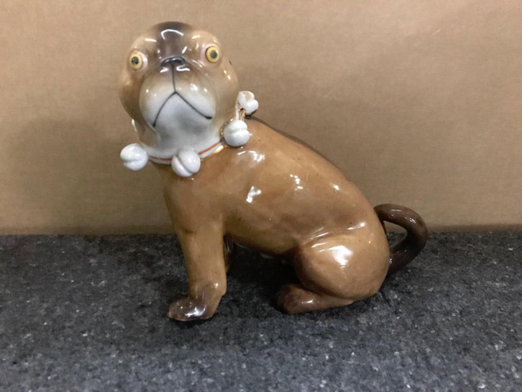 Single antique German porcelain seated pug dog, realistically modeled with bell collar.
 