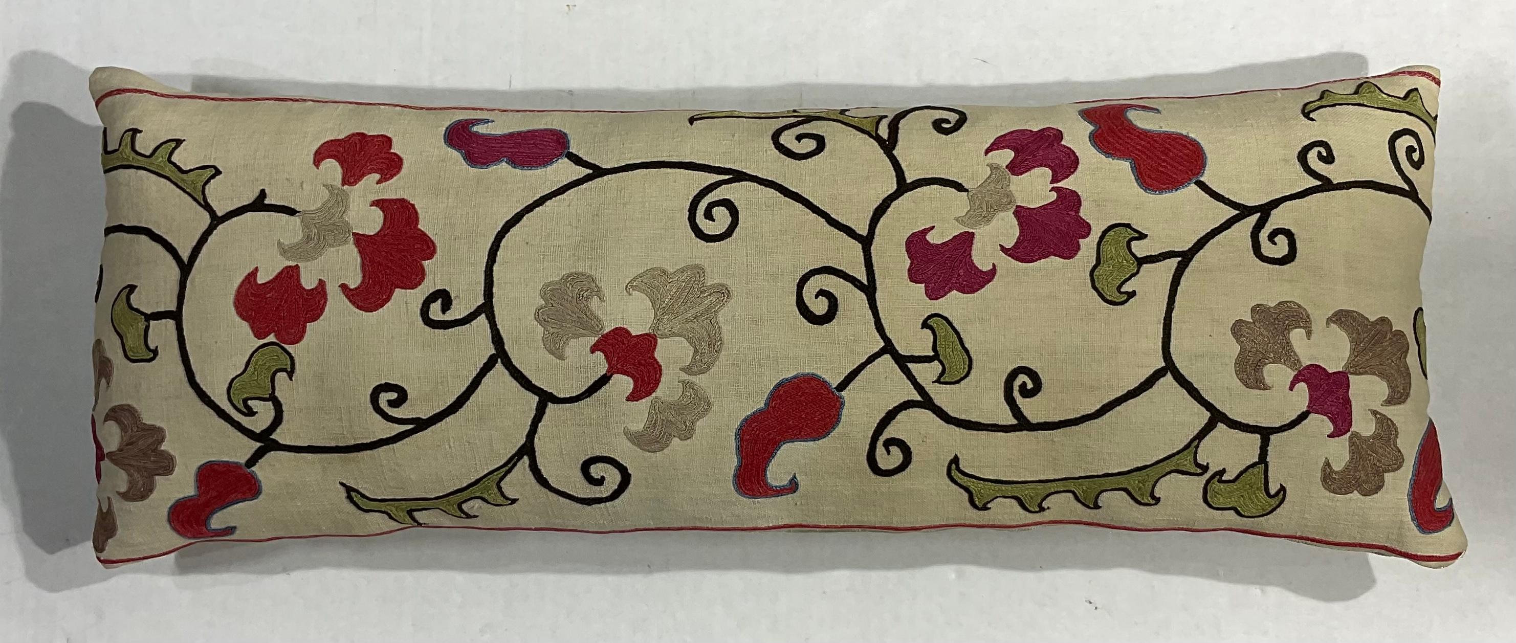 Coussin simple en tissu Suzani antique brodé à la main en soie, avec de beaux motifs de vignes et de fleurs. Insert de qualité fraîche, dos en coton fin. Quelques broderies manquantes dues à l'âge et à l'oxydation, quelques taches de décoloration,