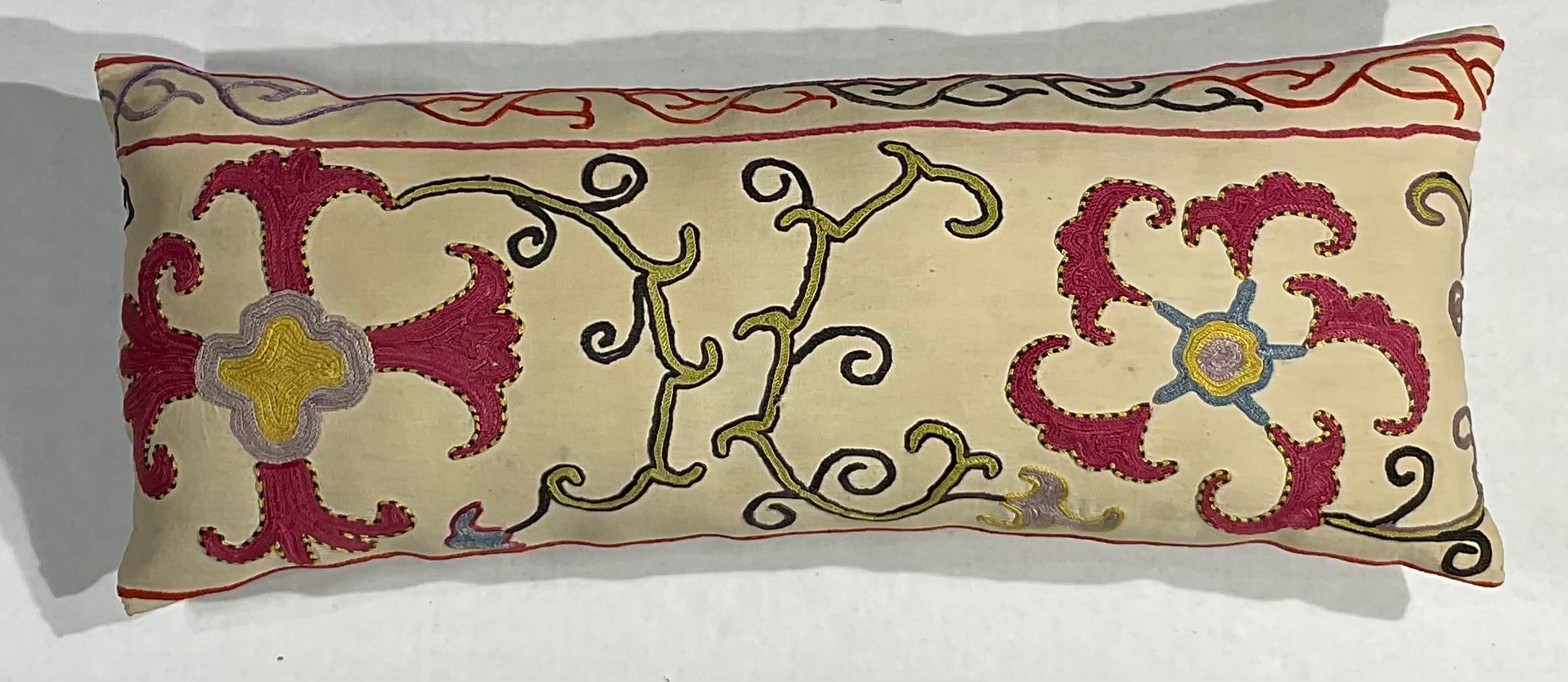 Coussin simple en tissu Suzani antique brodé à la main en soie, avec de beaux motifs de vignes et de fleurs. Insert de qualité fraîche, dos en coton fin. Quelques broderies manquantes dues à l'âge et à l'oxydation, quelques taches de décoloration,