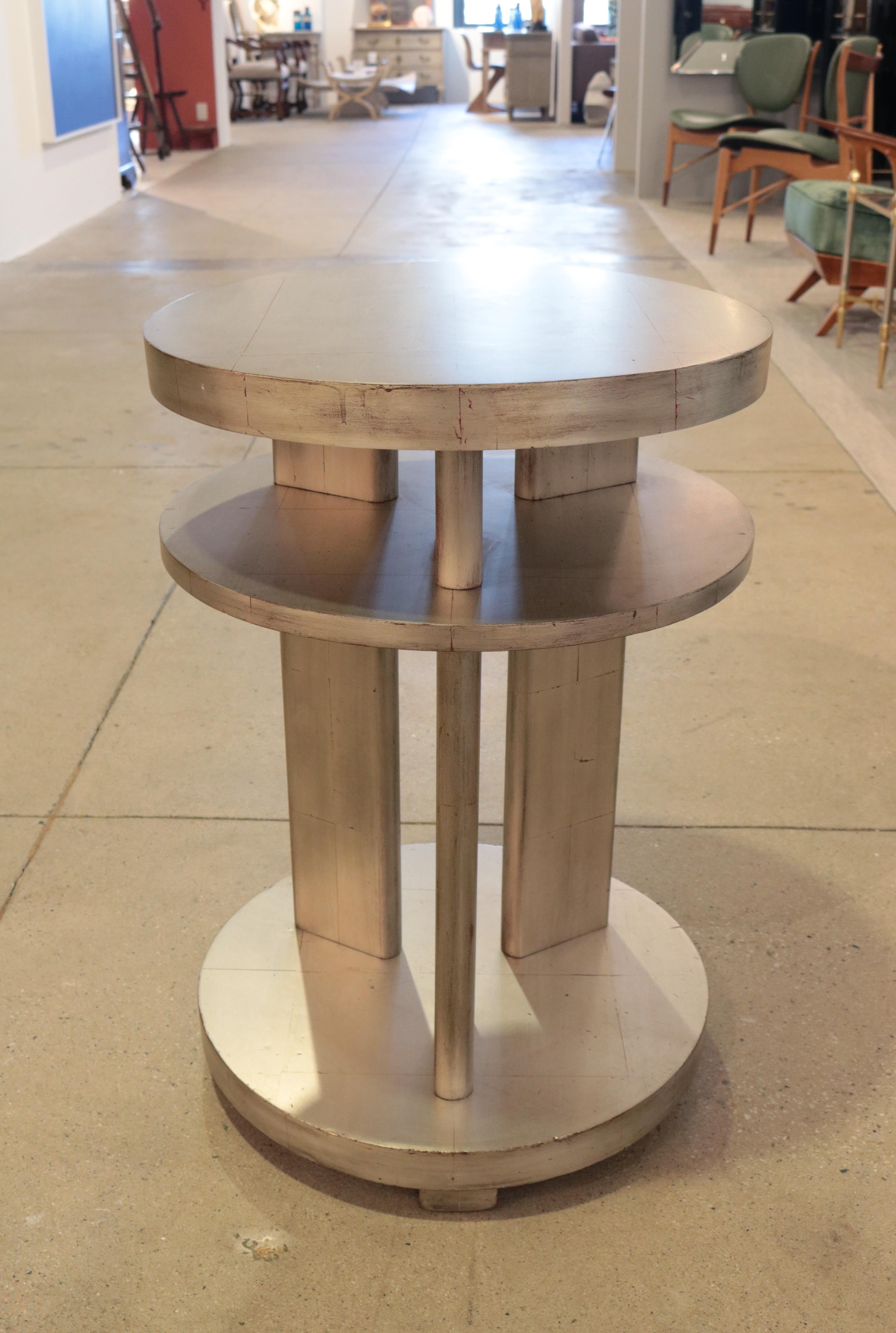 An Art Deco two-tiered side table in white gold leaf.