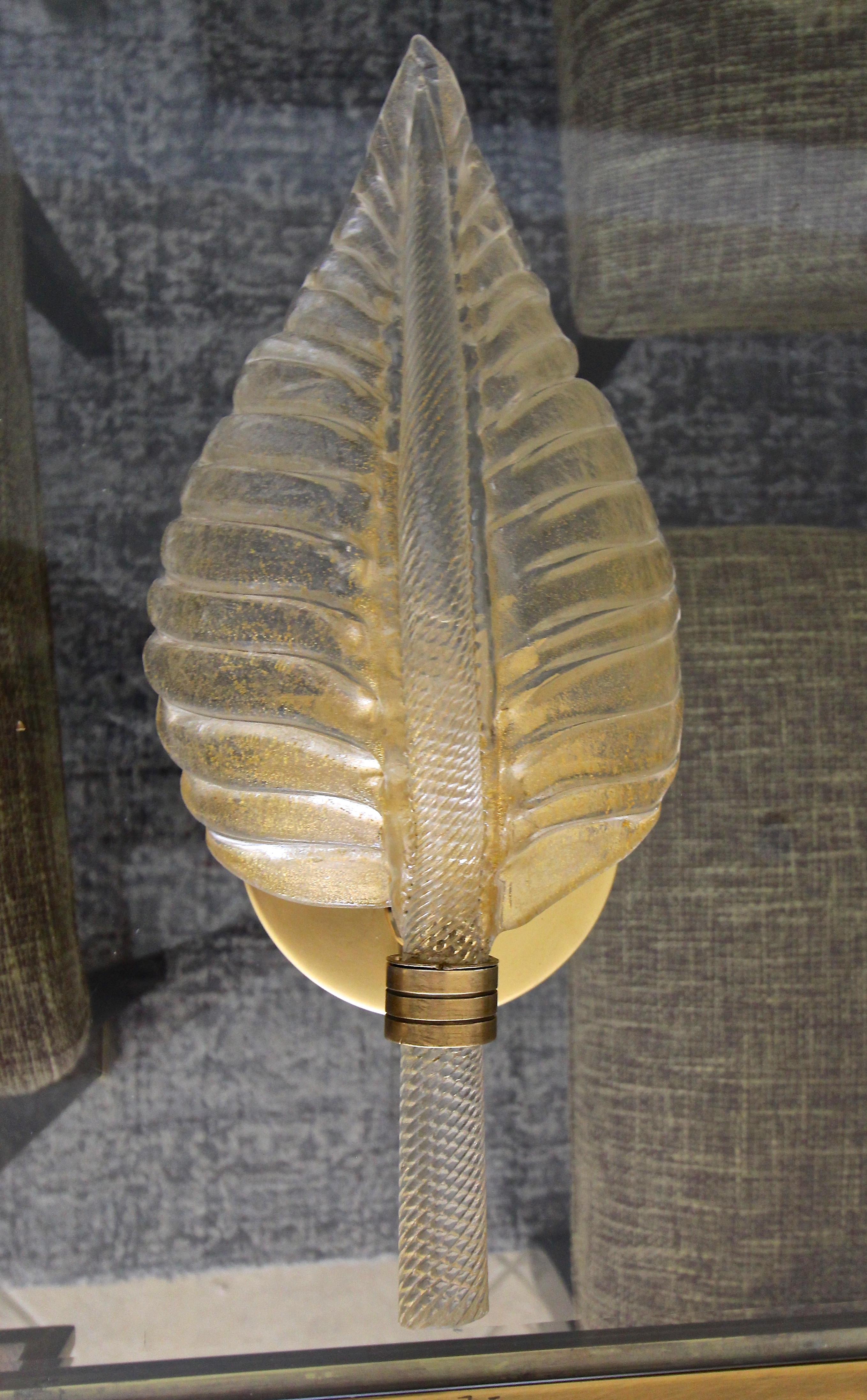One single hand blown Italian clear and gold inclusions glass leaf shaped wall sconce, supported on brass backplate. Leaf portion of the glass has a matte etched surface that diffuses light. Uses one candelabra size bulb, newly rewired. Original