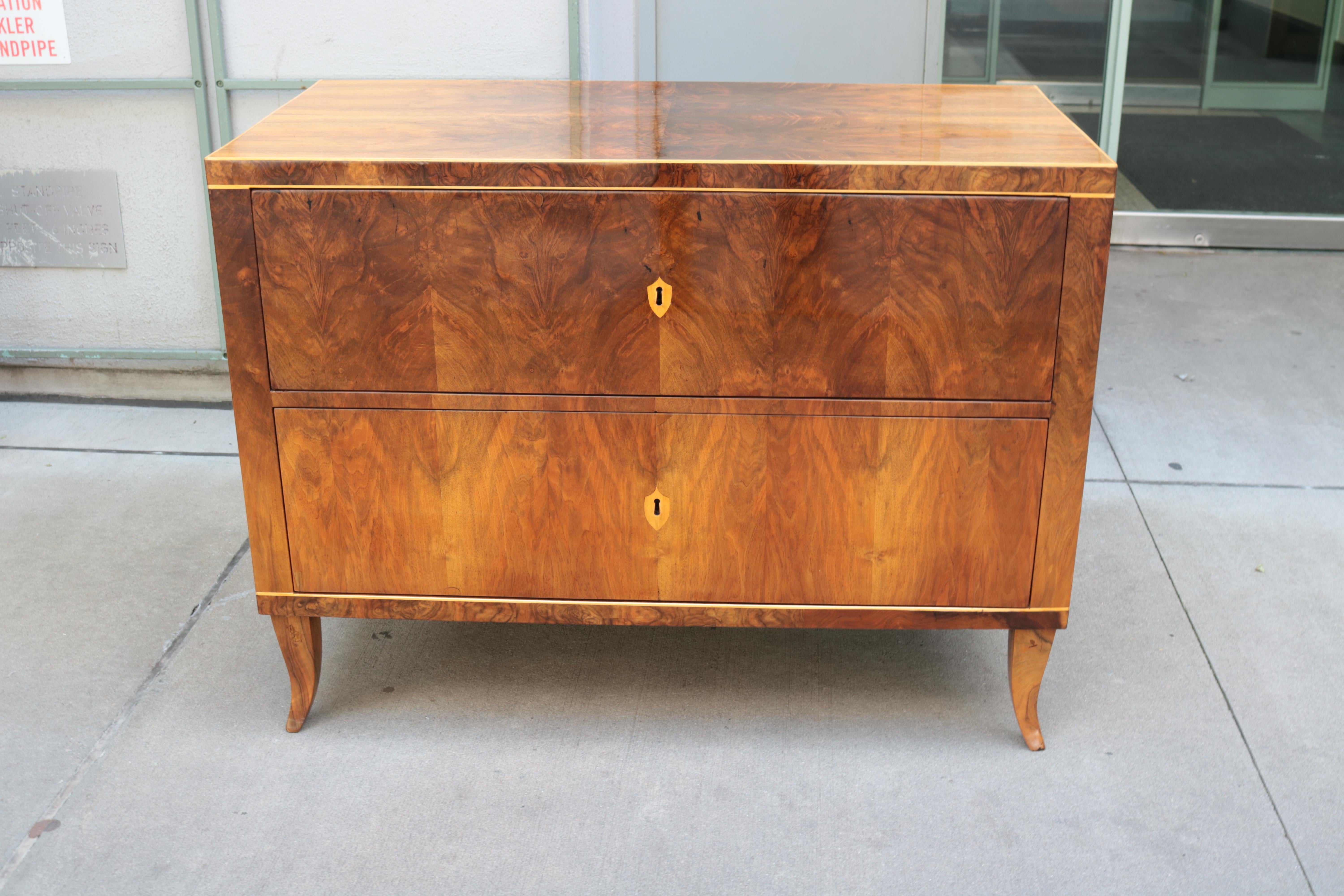 A fine Biedermeier single two drawer commode. 
Walnut with fruitwood inlay details.

 