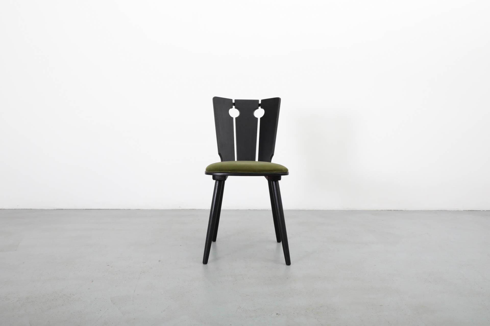 Brutalist style dining chair with parallel circular cut-outs, black stained oak frame, panels reinforced by metal clasps. Newly upholstered olive green velvet seat cushion. Frame in original condition with light signs of wear consistent with its age