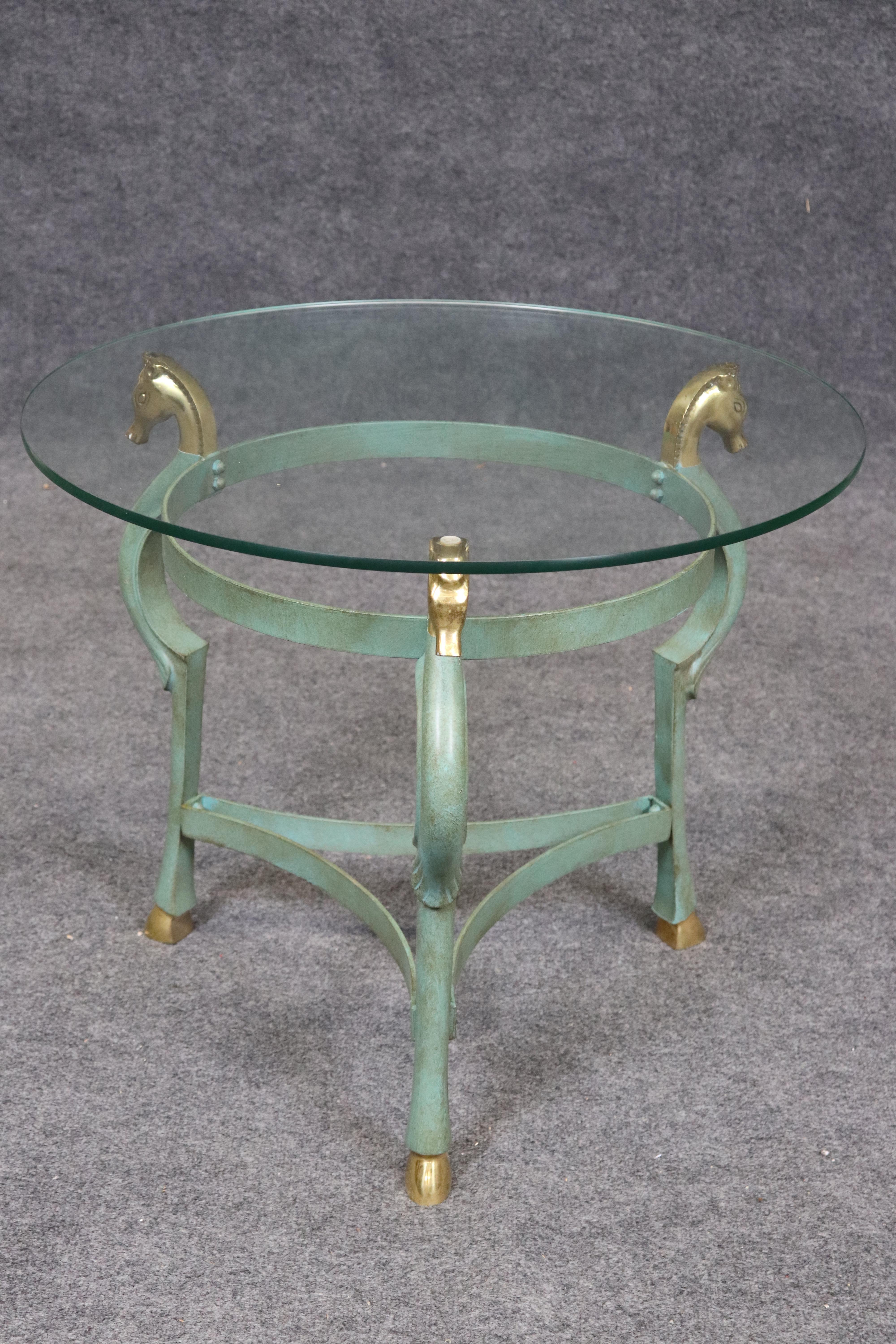 Voici une superbe table d'appoint de style Andre Arbus ou Maison Charles. La table est faite de Meta et de laiton et a reçu une finition vert bronze verdâtre avec des terminaisons en tête de cheval en laiton brillant. La table présente de légères