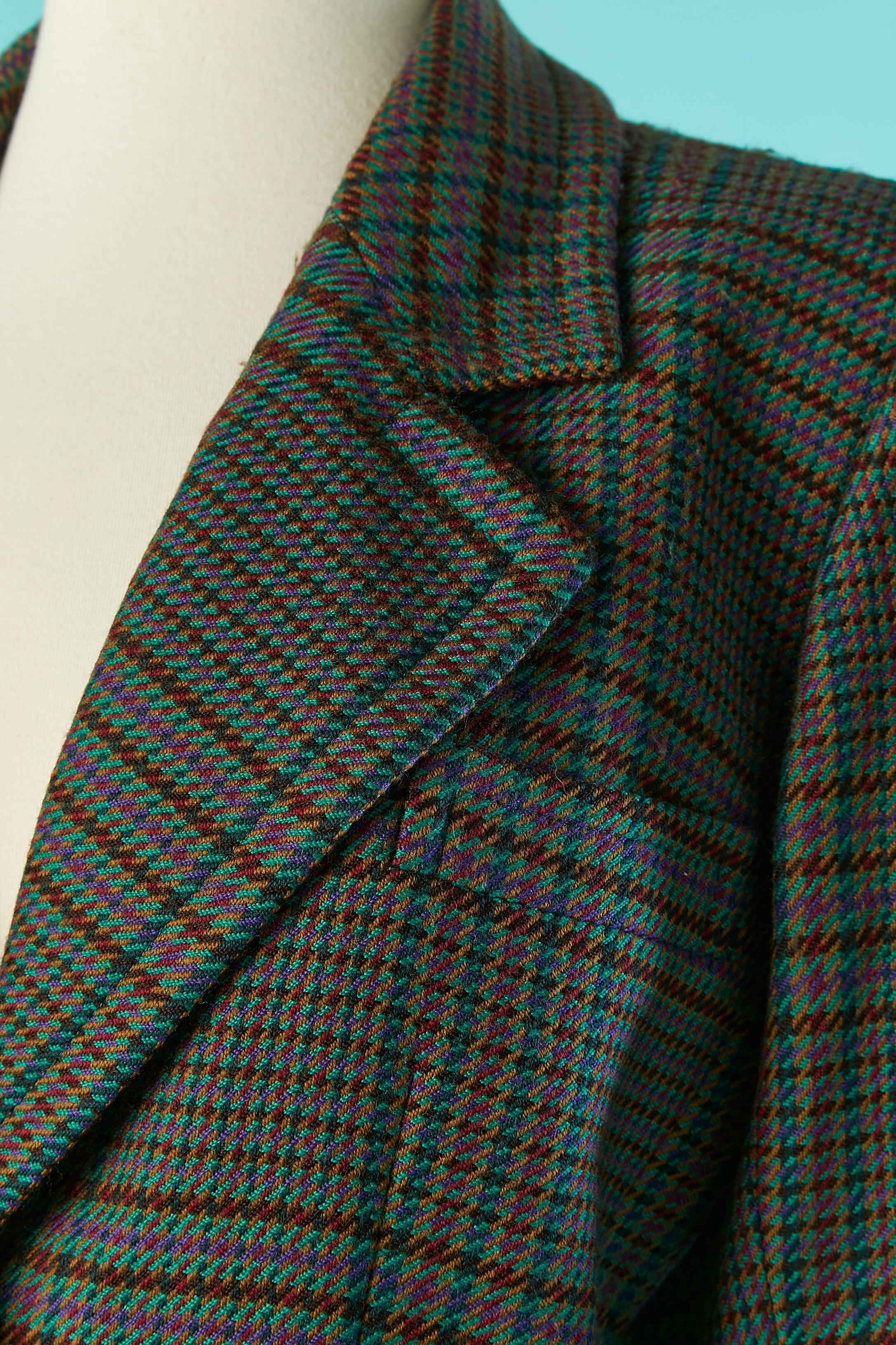 Veste en laine à simple boutonnage avec motif à carreaux. L'étiquette de composition du tissu a été coupée mais la doublure est probablement en rayonne ou en acétate. 
Pad d'épaule. Poches sur les deux côtés. 
TAILLE 36 (Fr) M 