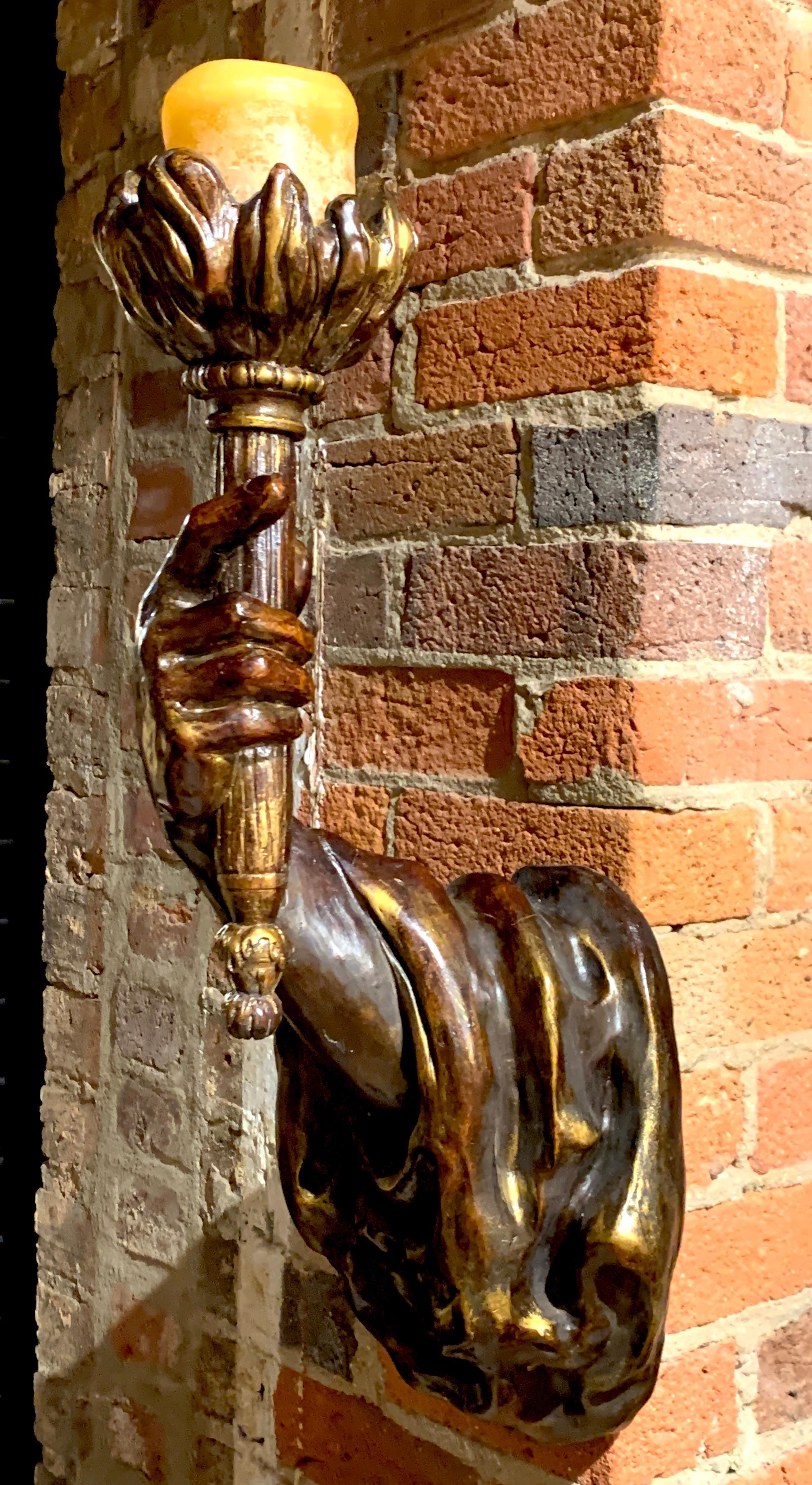 Einzelner bronzeverkleideter (Bronze über Gips) Armleuchter im venezianischen Stil mit drapiertem Arm, realistisch modelliert und polychromiert, der eine Fackelkerze hält.
 