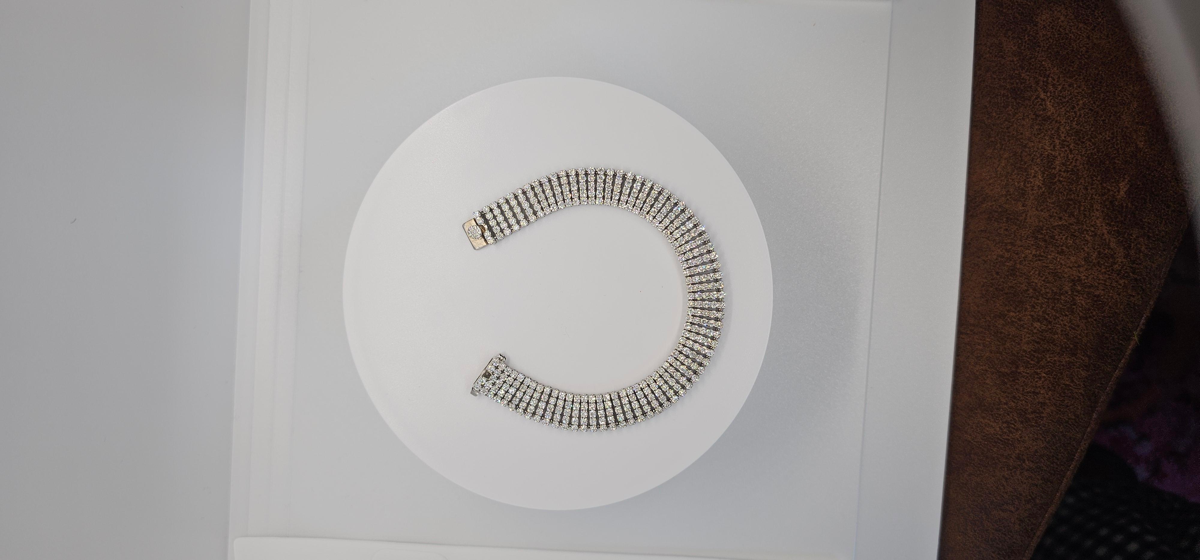 The Convertible Tennis Bracelet—a true testament to elegance and versatility. This stunning bracelet is crafted from 14k white gold and set with an impressive 8.18 carats of natural, high-quality VVS-VS diamonds, each handpicked for their