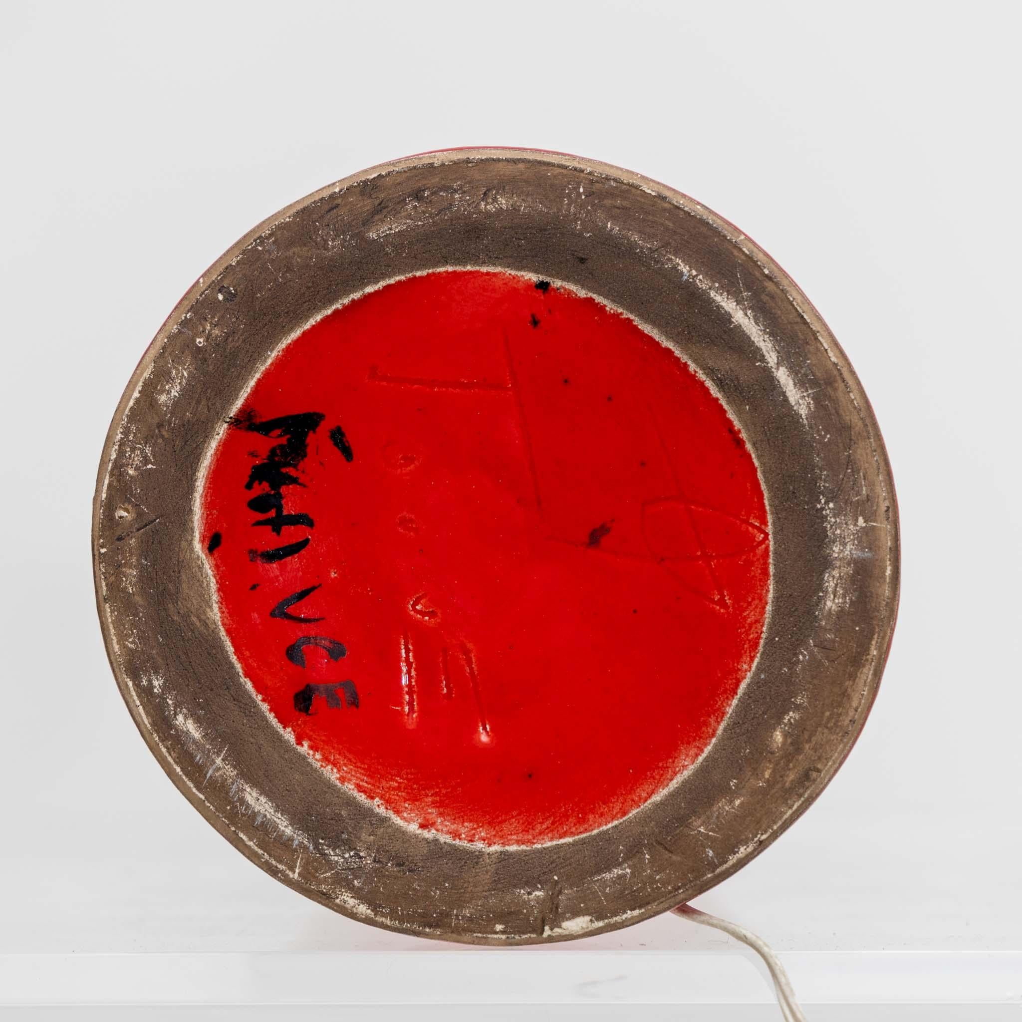 Lampe de table en céramique attribuée à Georges Jouve.
Grès émaillé rouge, laiton.