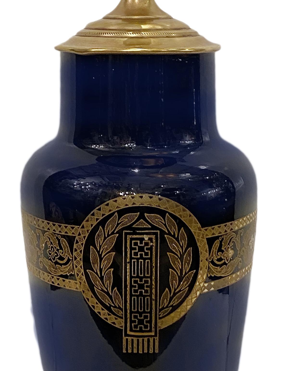 A circa 1900's French cobalt blue porcelain table lamp with gold painted detailing and bronze and pewter base.

Measurements:
Height of body: 13.5